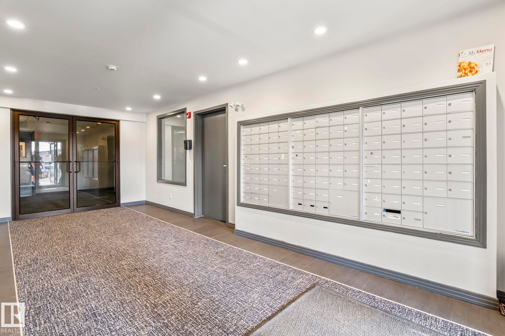 Interior mailboxes featuring a grey trim against a white wall - 412 5005 165 Avenue Nw, Edmonton, AB - Indoor Photo Showing Other Room