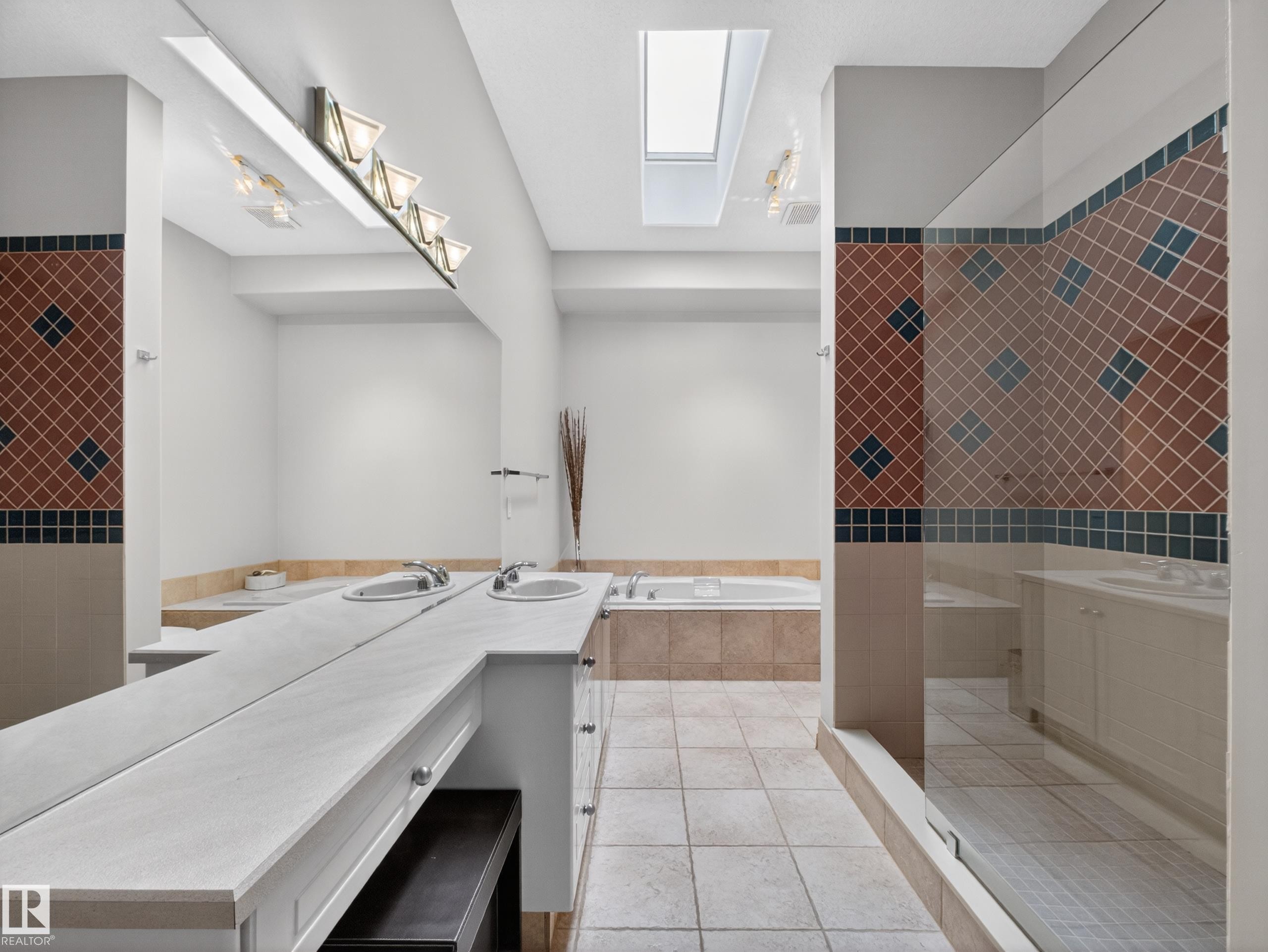 Spacious bathroom featuring dual vanity with integrated sinks, a large soaking tub, and a separate glass-enclosed shower - 569 Butterworth Way, Edmonton, AB - Indoor