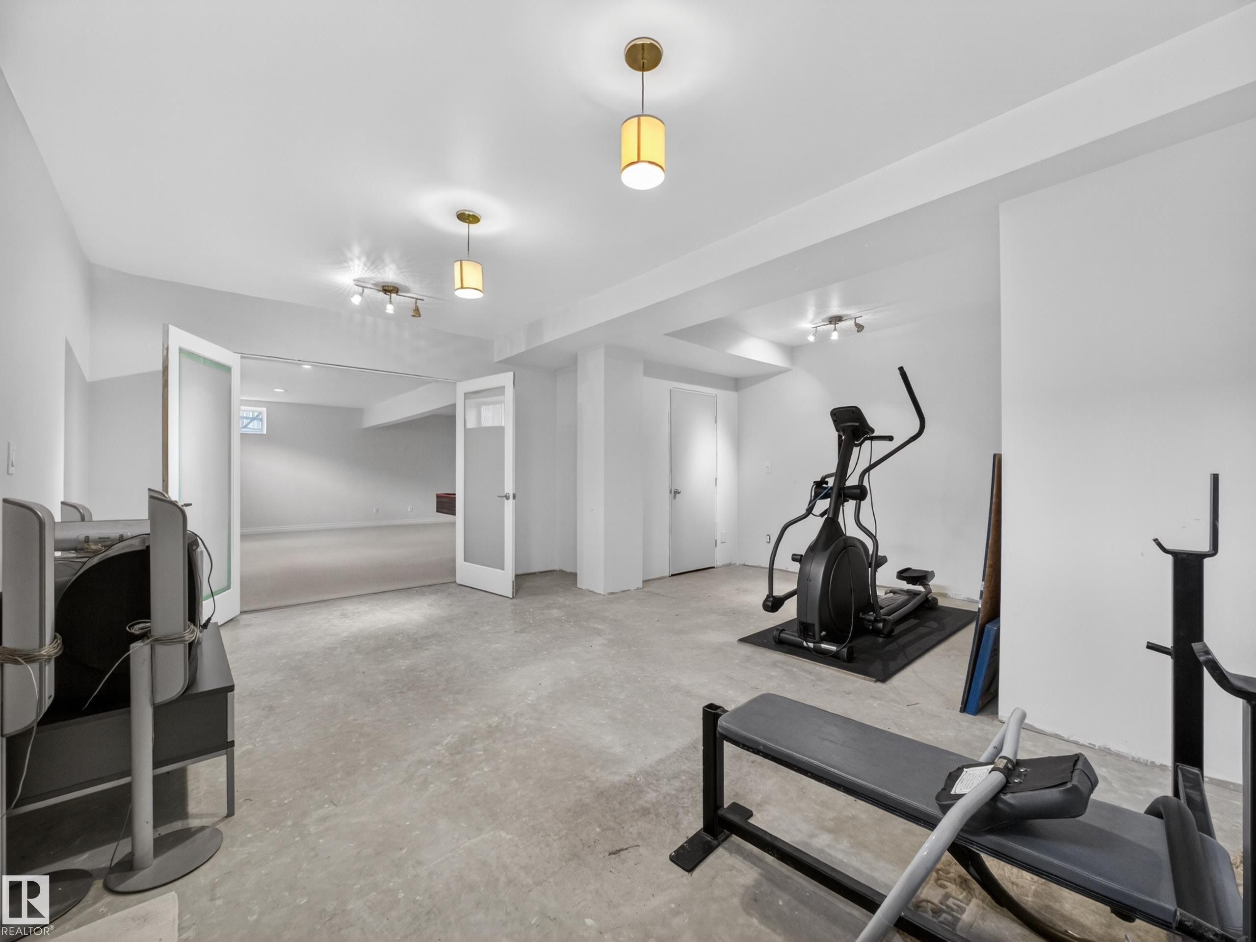 Spacious lower-level area with concrete flooring and recessed lighting - 569 Butterworth Way, Edmonton, AB - Indoor Photo Showing Gym Room