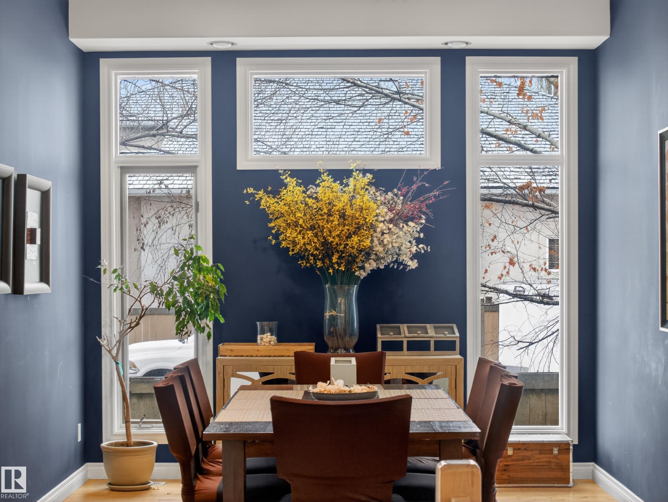 Formal dining space featuring tall windows and rich blue walls - 569 Butterworth Way, Edmonton, AB - Indoor Photo Showing Dining Room