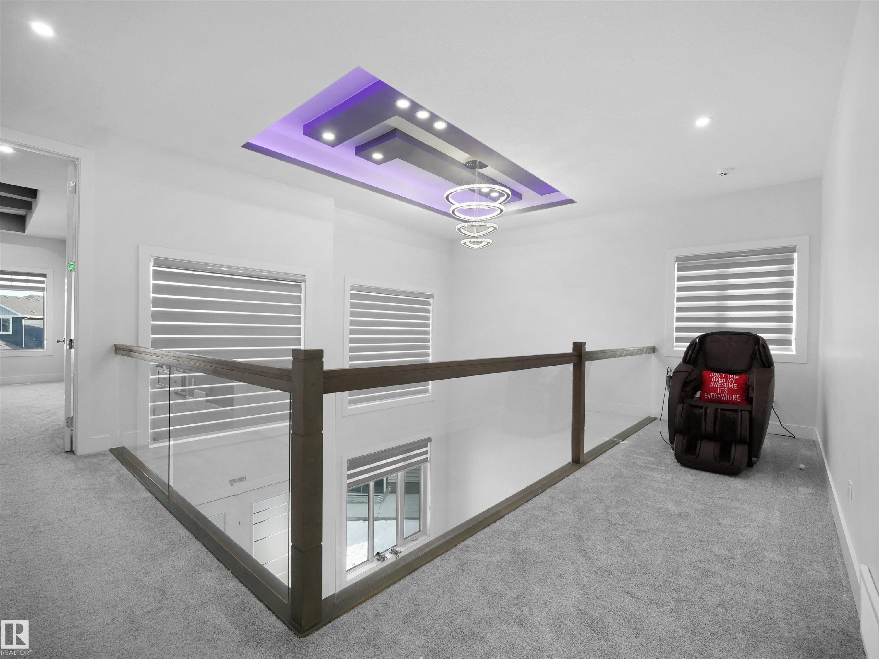 Upper-level landing featuring a custom tray ceiling with recessed lighting and a contemporary multi-ring chandelier - 1208 25 St Nw, Edmonton, AB - Indoor Photo Showing Other Room