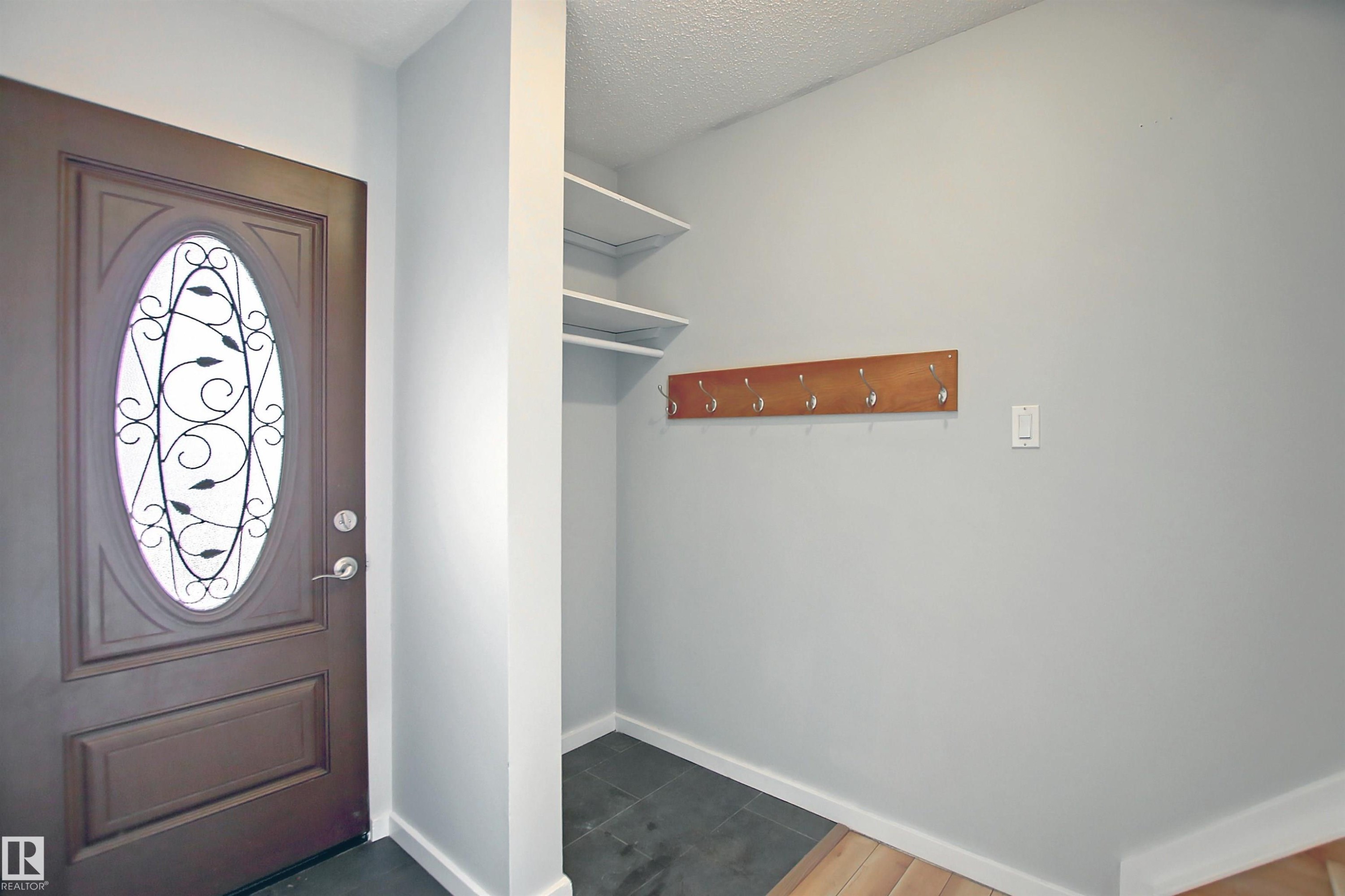 Entryway featuring a dark wood door with an oval decorative glass insert - 11 14120 80 Street, Edmonton, AB - Indoor Photo Showing Other Room