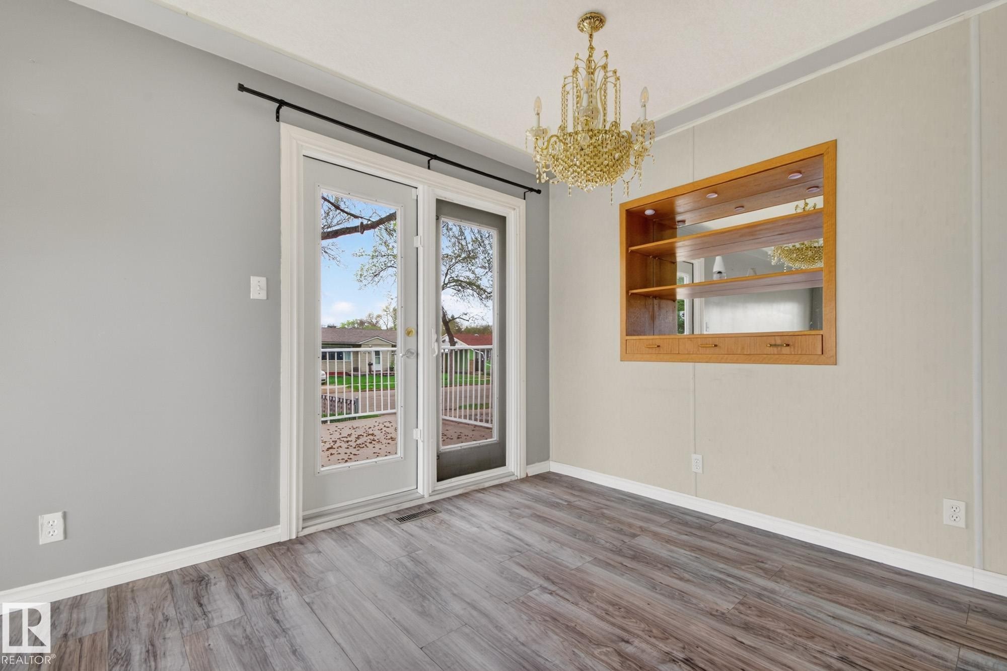 Glass-paned double doors opening to an outdoor balcony - 11901 42 Street Nw, Edmonton, AB - Indoor Photo Showing Other Room