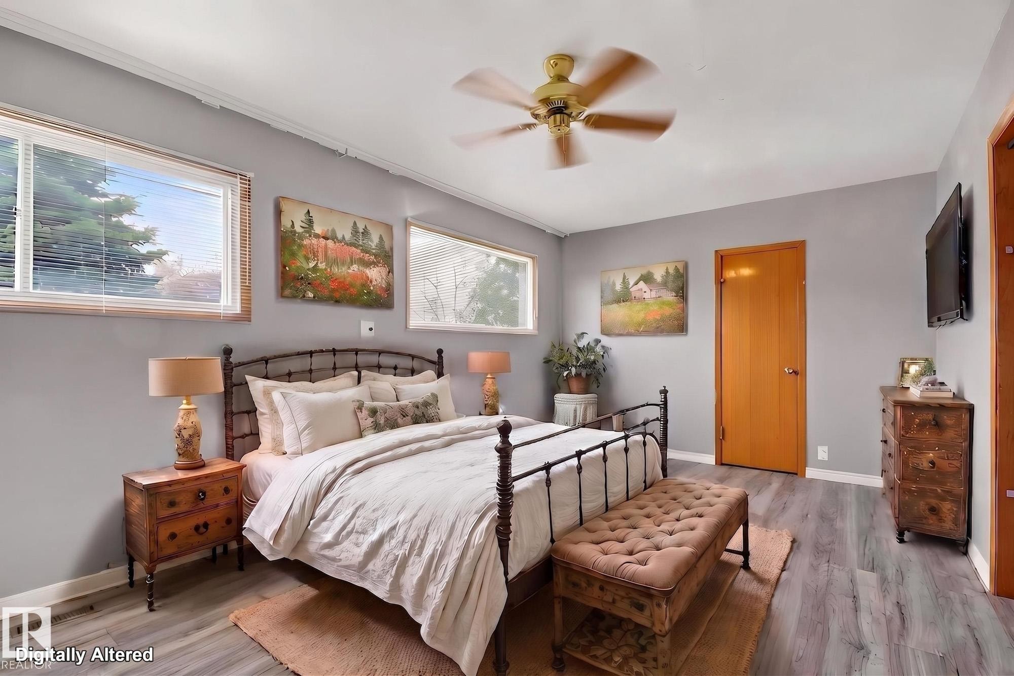 Spacious room with wood-finish flooring, light grey walls, and a ceiling fan - 11901 42 Street Nw, Edmonton, AB - Indoor Photo Showing Bedroom