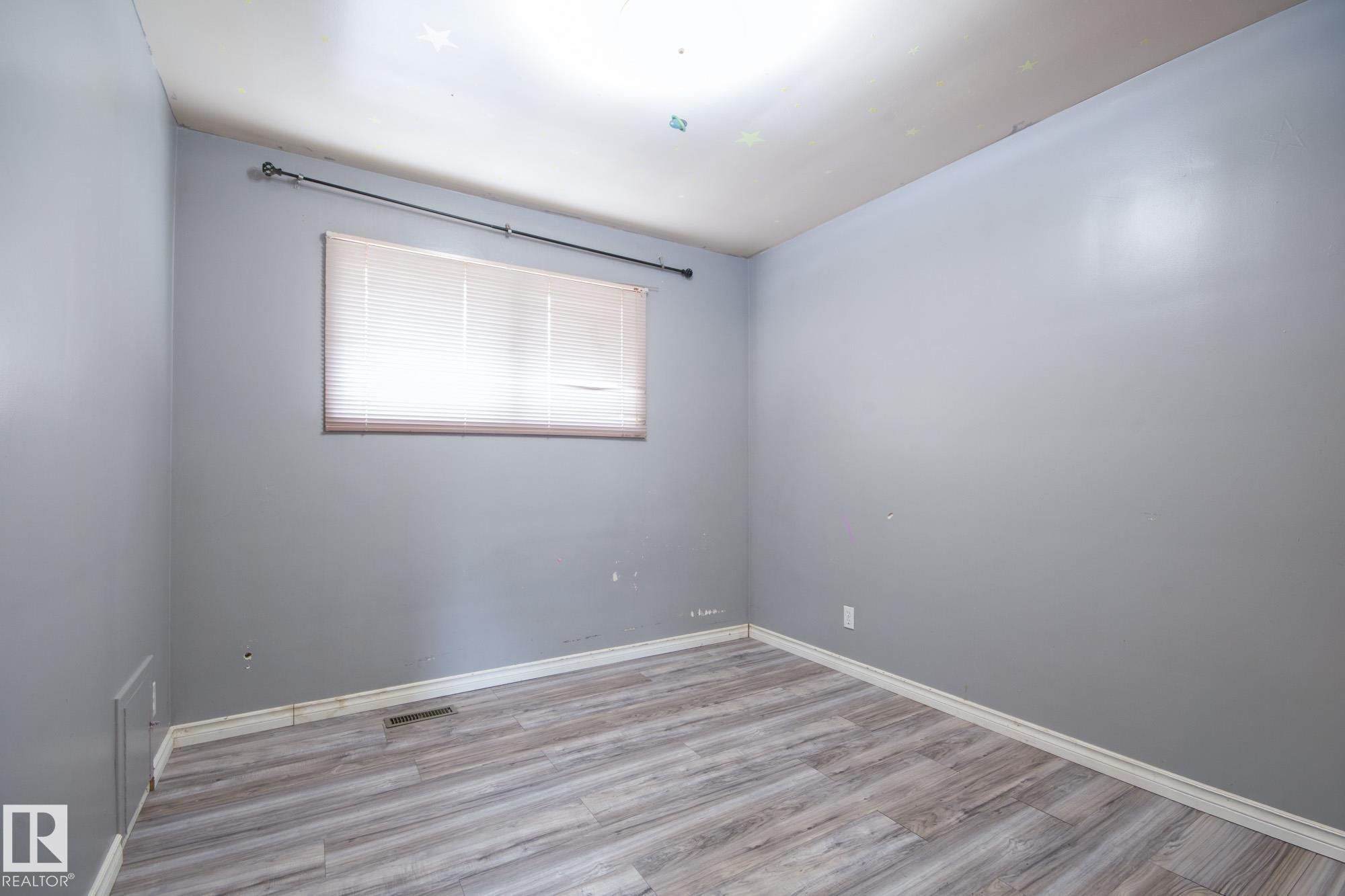 Room featuring wood-finish flooring, a single window with blinds, and light-toned wall paint - 11901 42 Street Nw, Edmonton, AB - Indoor Photo Showing Other Room