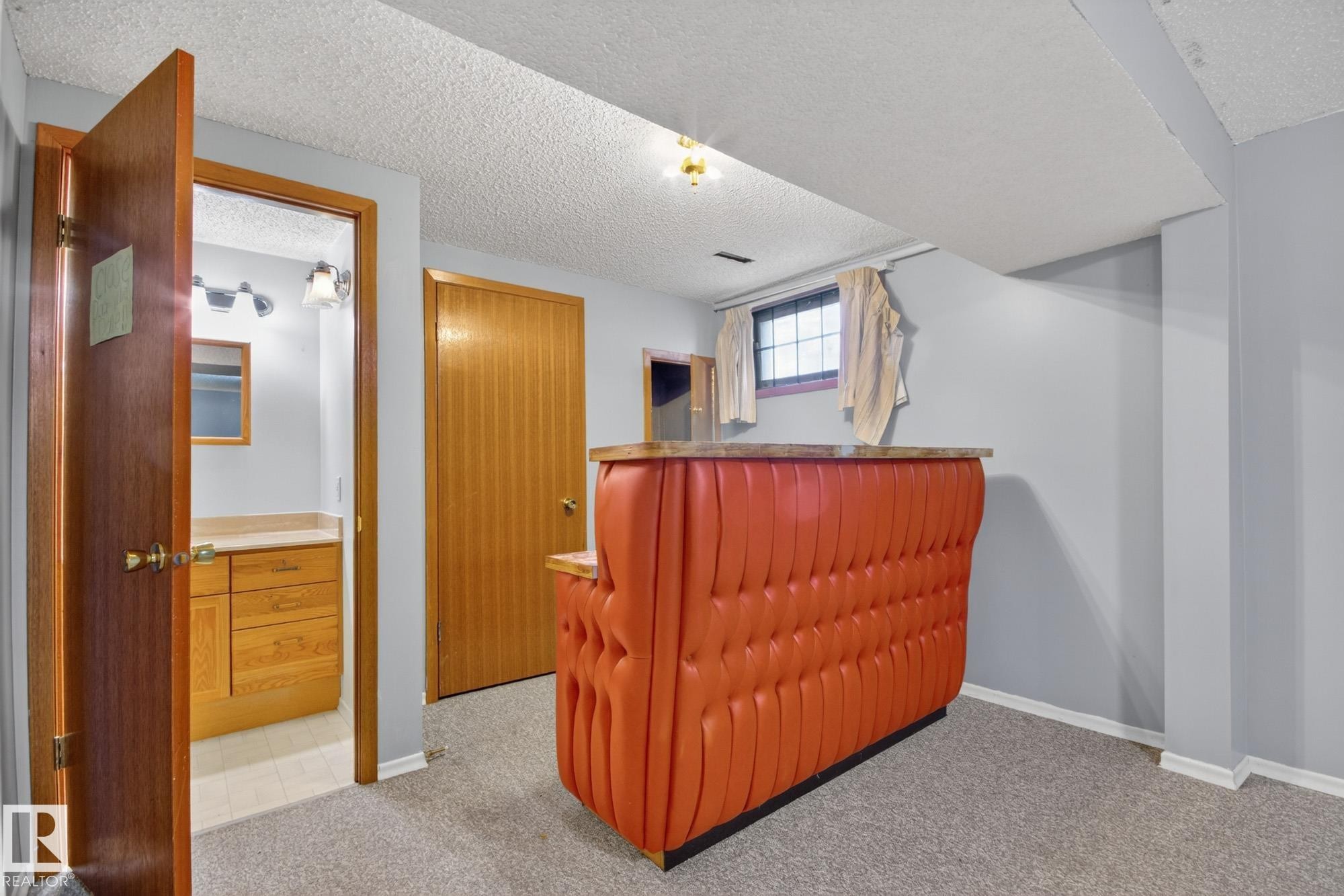 Tufted bar with a stone-finish countertop, light gray walls, and textured carpeting - 11901 42 Street Nw, Edmonton, AB - Indoor