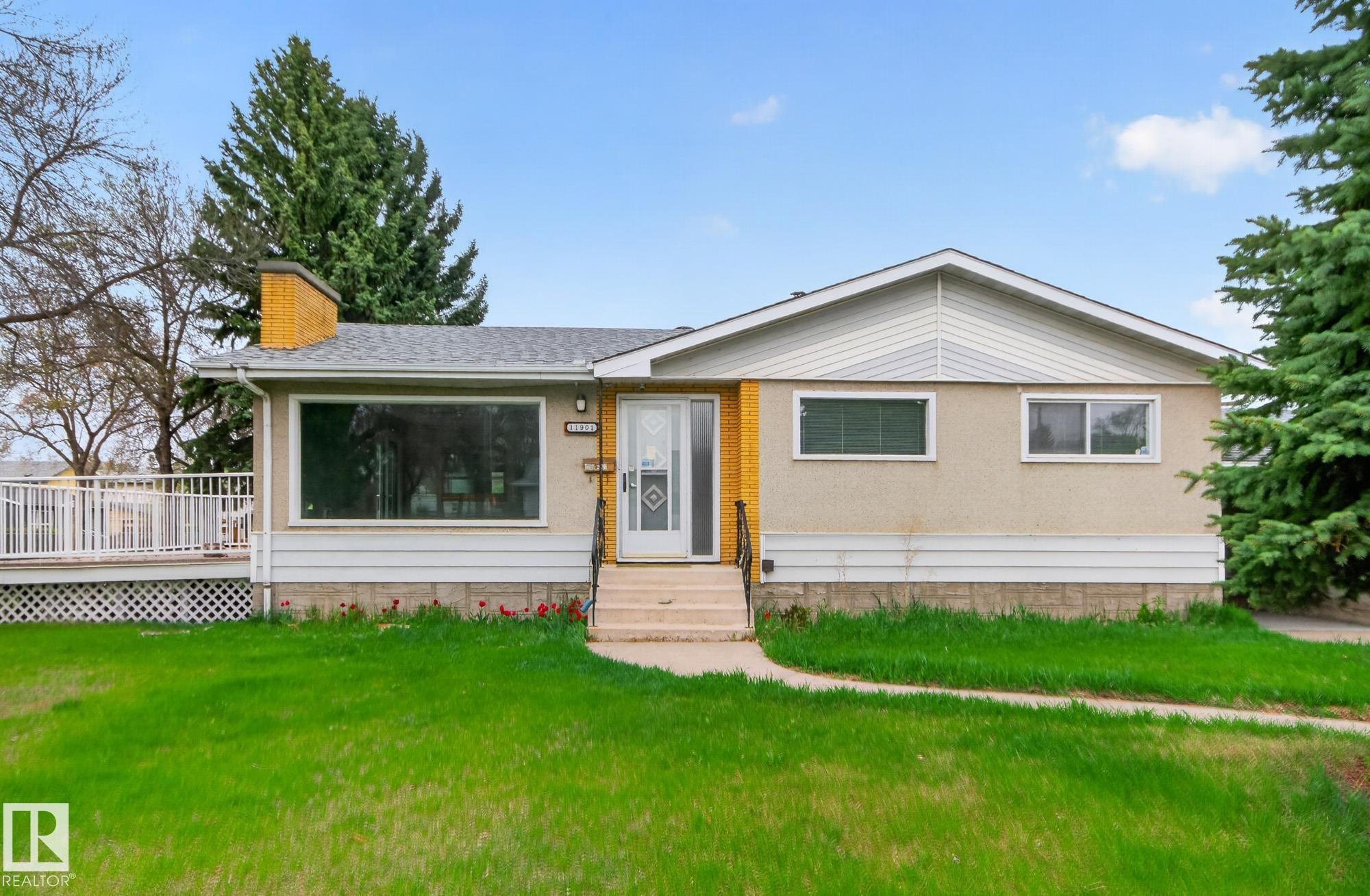 Single-story residence featuring a front walkway leading to the entry, a prominent front window, and a white deck with railings - 11901 42 Street Nw, Edmonton, AB - Outdoor With Deck Patio Veranda