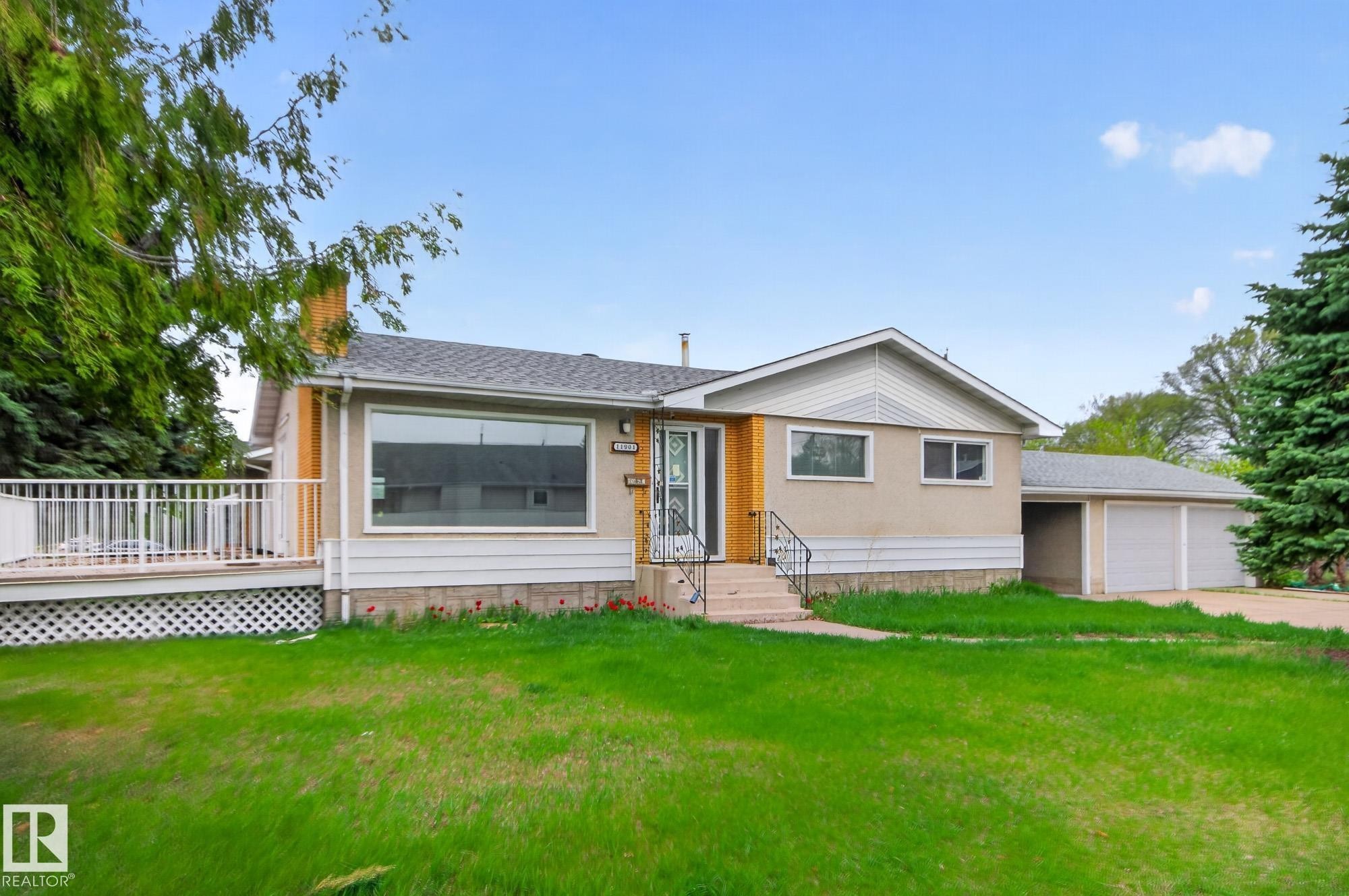 Ranch-style residence featuring a two-car garage, front lawn, and a side deck with white railings - 11901 42 Street Nw, Edmonton, AB - Outdoor With Deck Patio Veranda