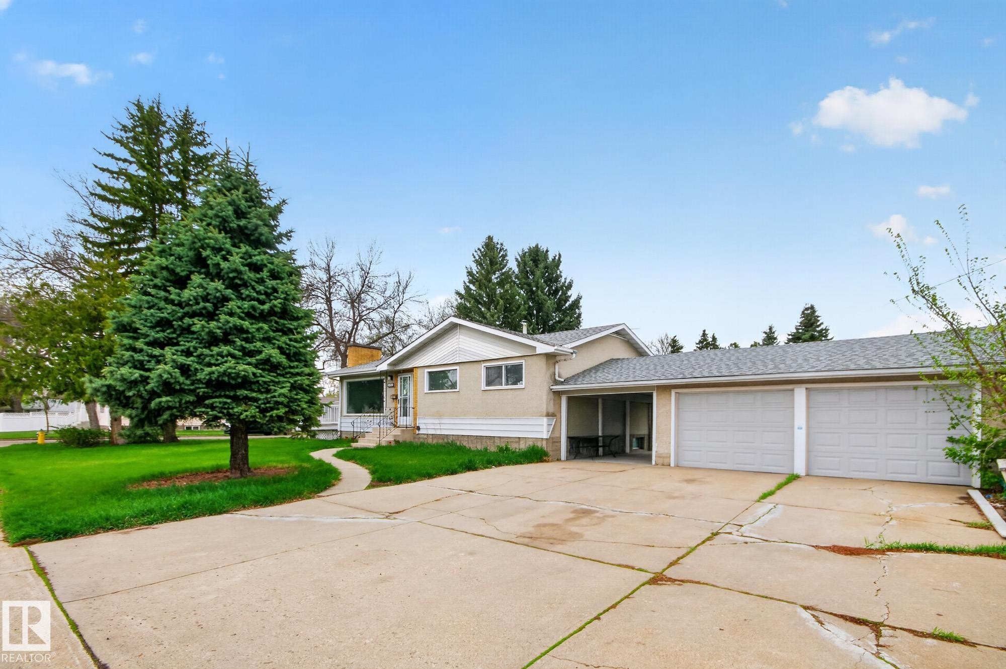 Exterior featuring a gabled roofline, concrete driveway, and a two-car attached garage - 11901 42 Street Nw, Edmonton, AB - Outdoor