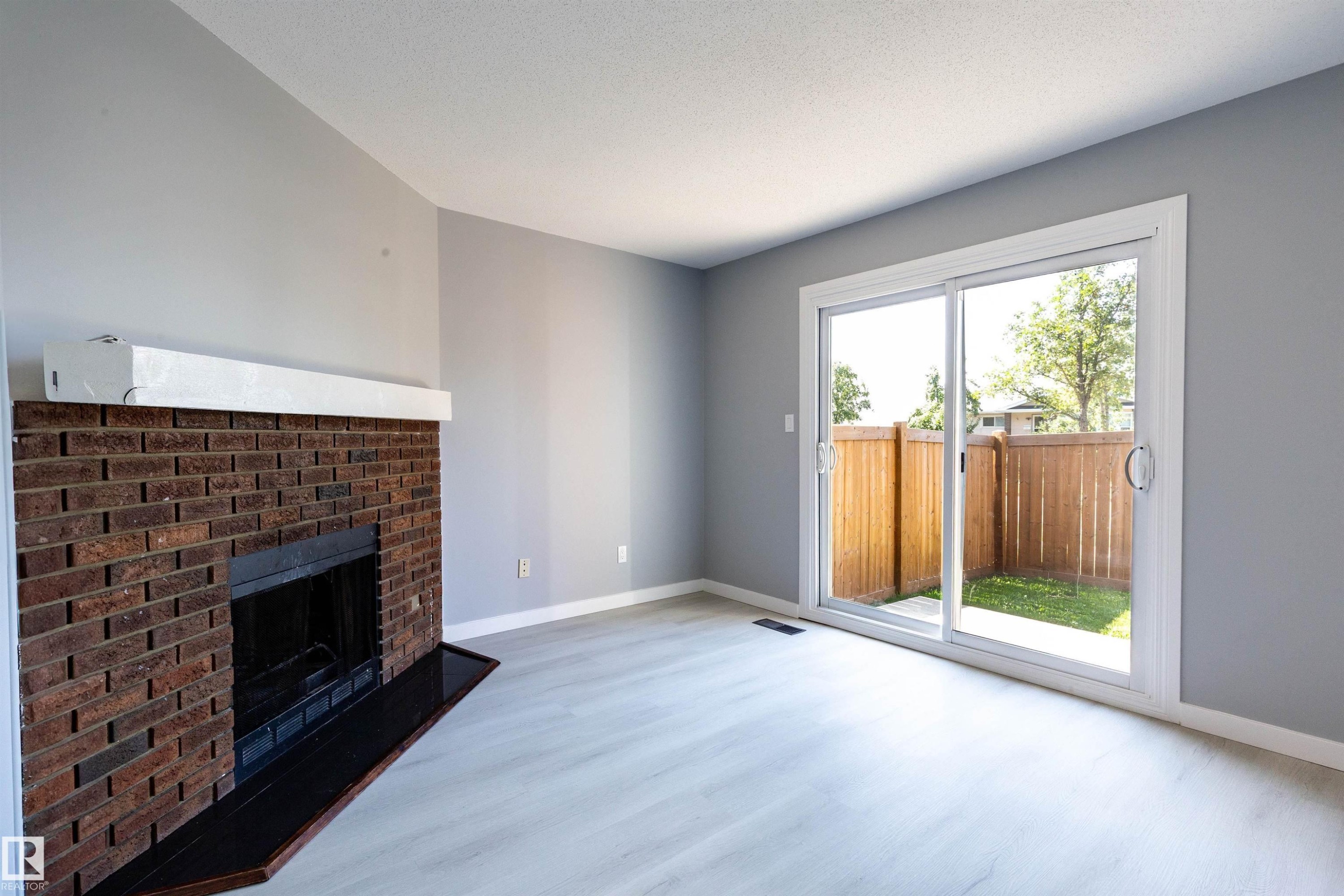 Spacious interior featuring light wood-finish flooring and light gray walls - 547 Dunluce Road, Edmonton, AB - Indoor Photo Showing Living Room With Fireplace