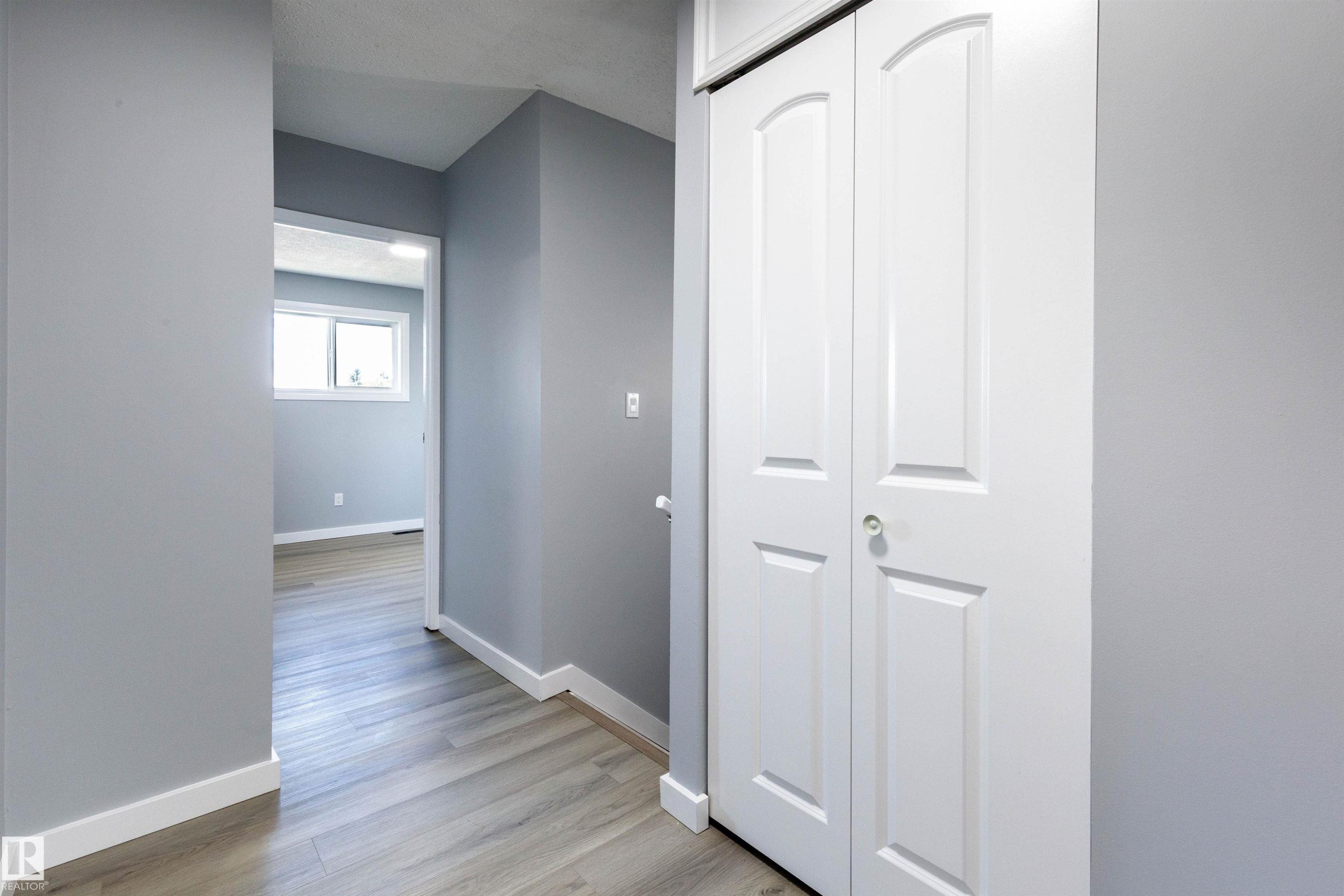 Hallway featuring light gray walls, white baseboards, and wood-finish flooring - 547 Dunluce Road, Edmonton, AB - Indoor Photo Showing Other Room