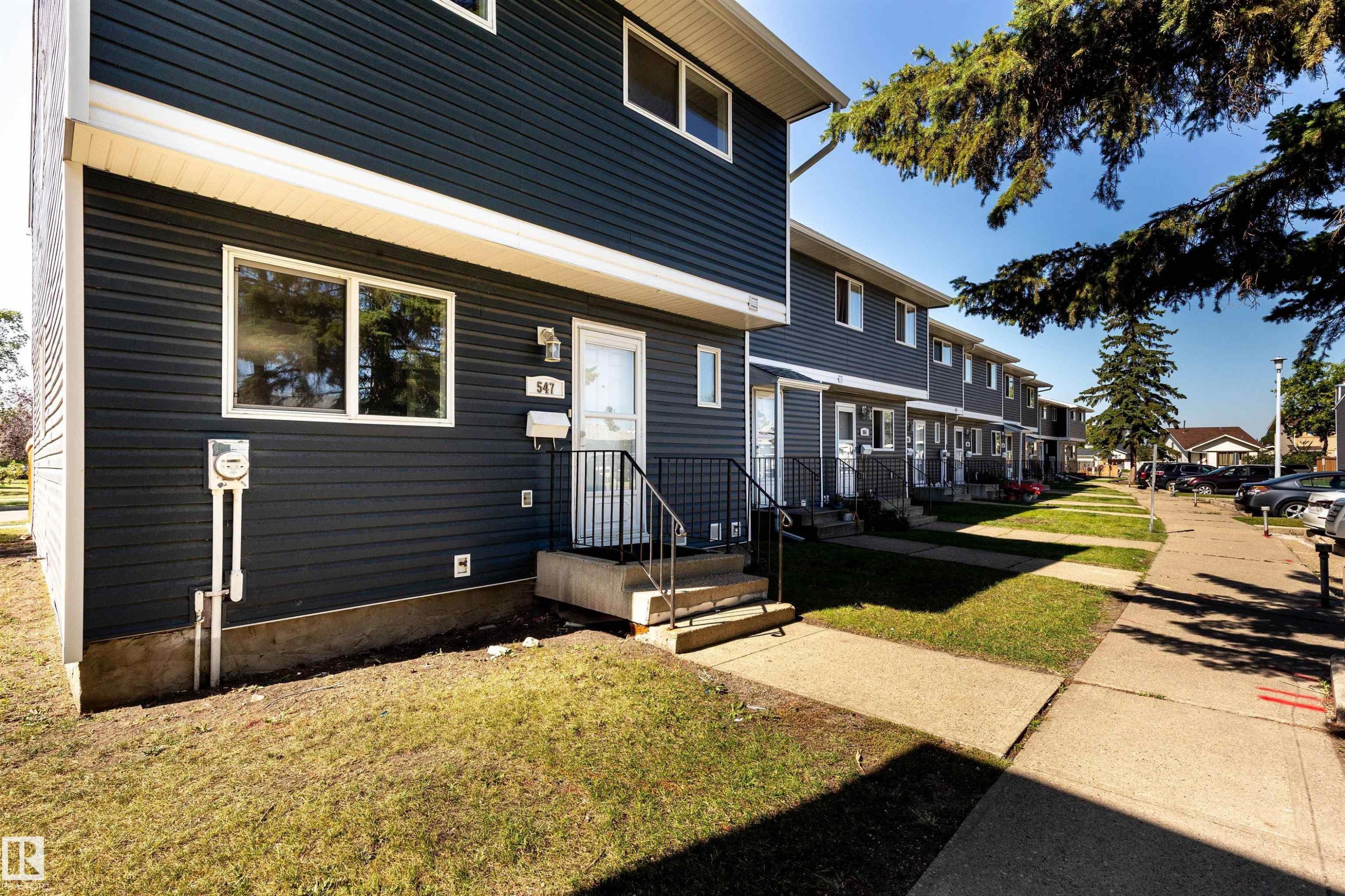 Two-story townhome featuring dark gray siding and white trim - 547 Dunluce Road, Edmonton, AB - Outdoor