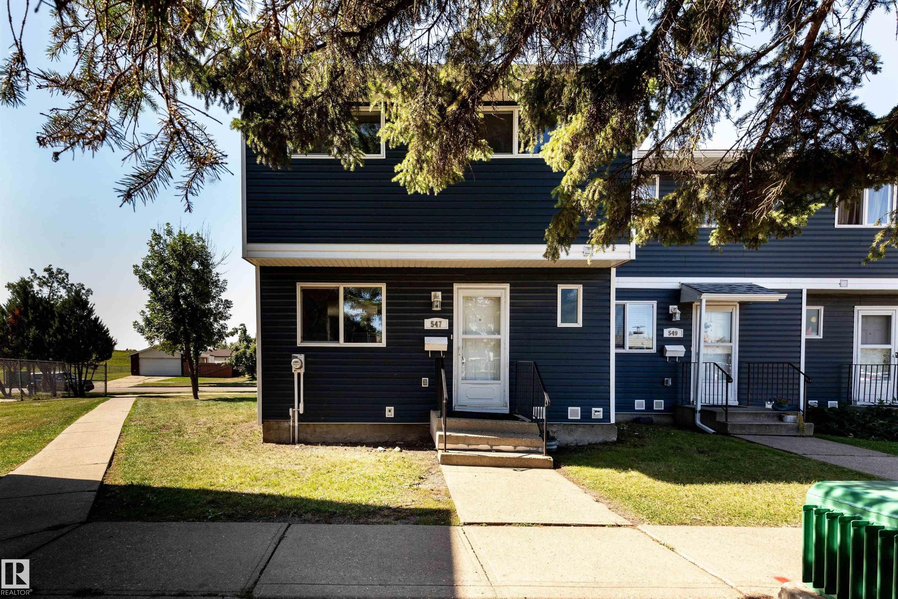 Two-story property featuring dark blue horizontal siding and white trim - 547 Dunluce Road, Edmonton, AB - Outdoor With Facade