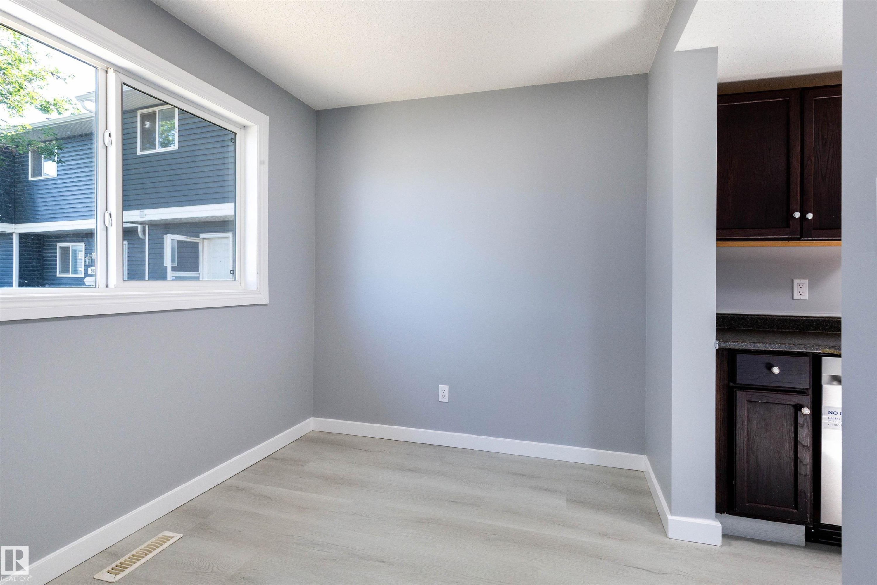 Spacious room featuring light grey walls, wood-finish flooring, and white trim throughout - 547 Dunluce Road, Edmonton, AB - Indoor Photo Showing Other Room