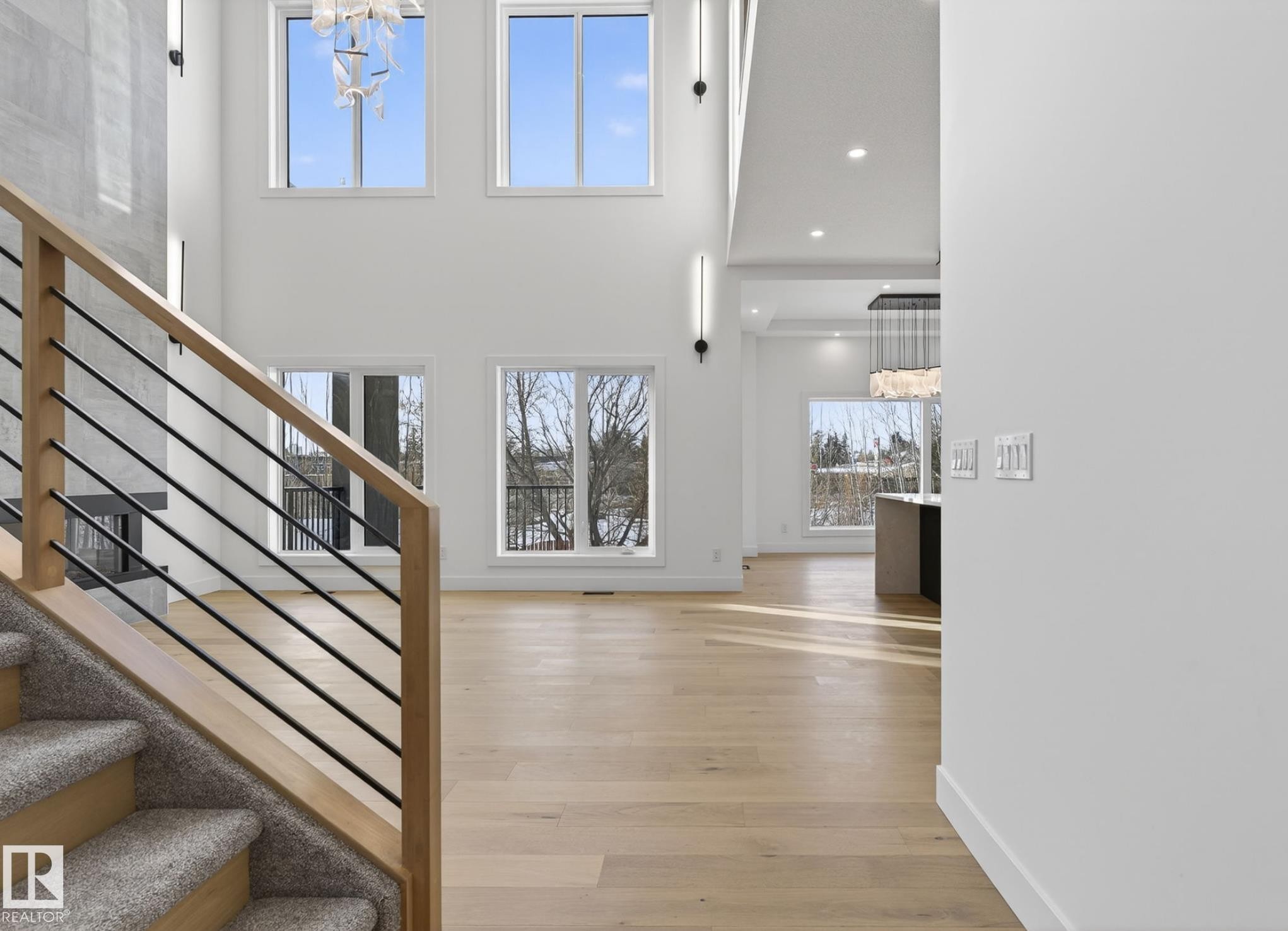 Staircase with carpeted treads and natural wood handrail with black metal balusters - 5820 110 Street, Edmonton, AB - Indoor Photo Showing Other Room