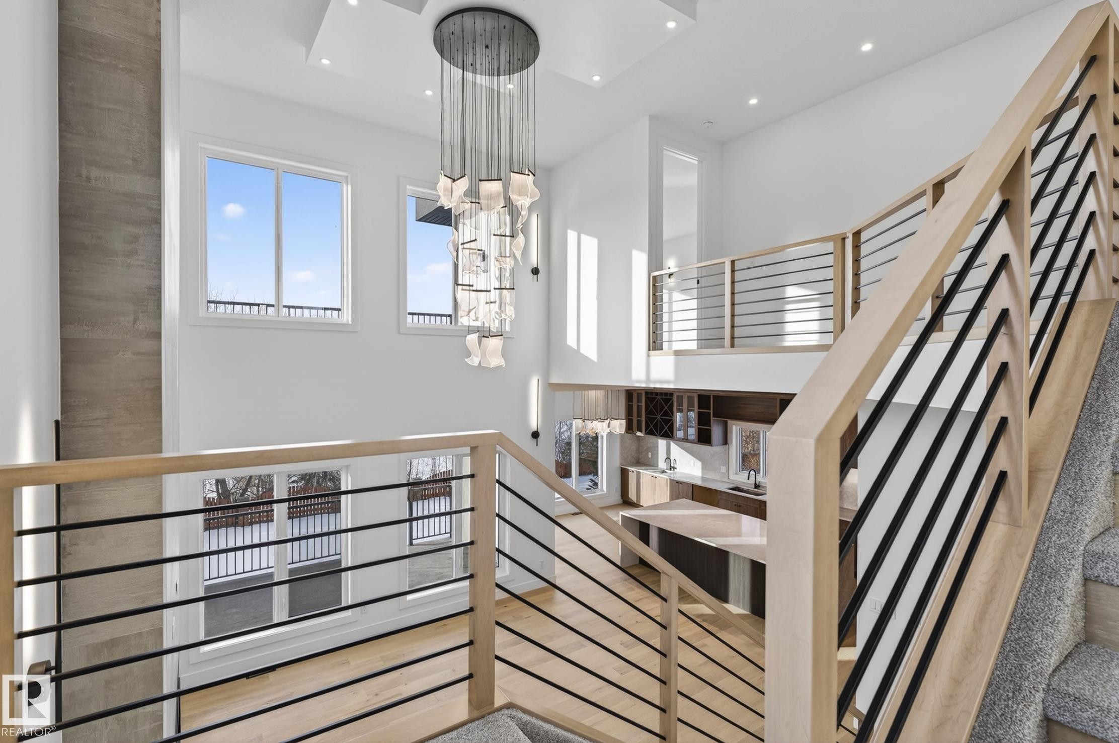Modern open-concept interior featuring light wood-finish flooring, a two-story ceiling, and multiple large windows - 5820 110 Street, Edmonton, AB - Indoor Photo Showing Other Room