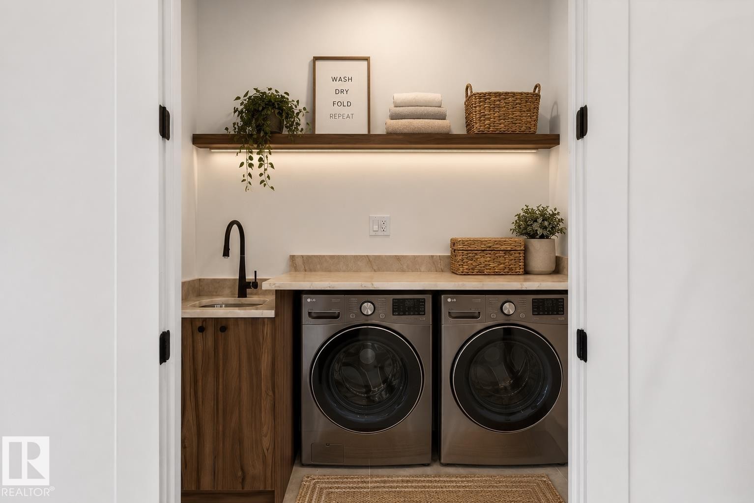 Compact laundry area featuring a built-in countertop with an undermount sink and matte black faucet - 5820 110 Street, Edmonton, AB - Indoor Photo Showing Laundry Room
