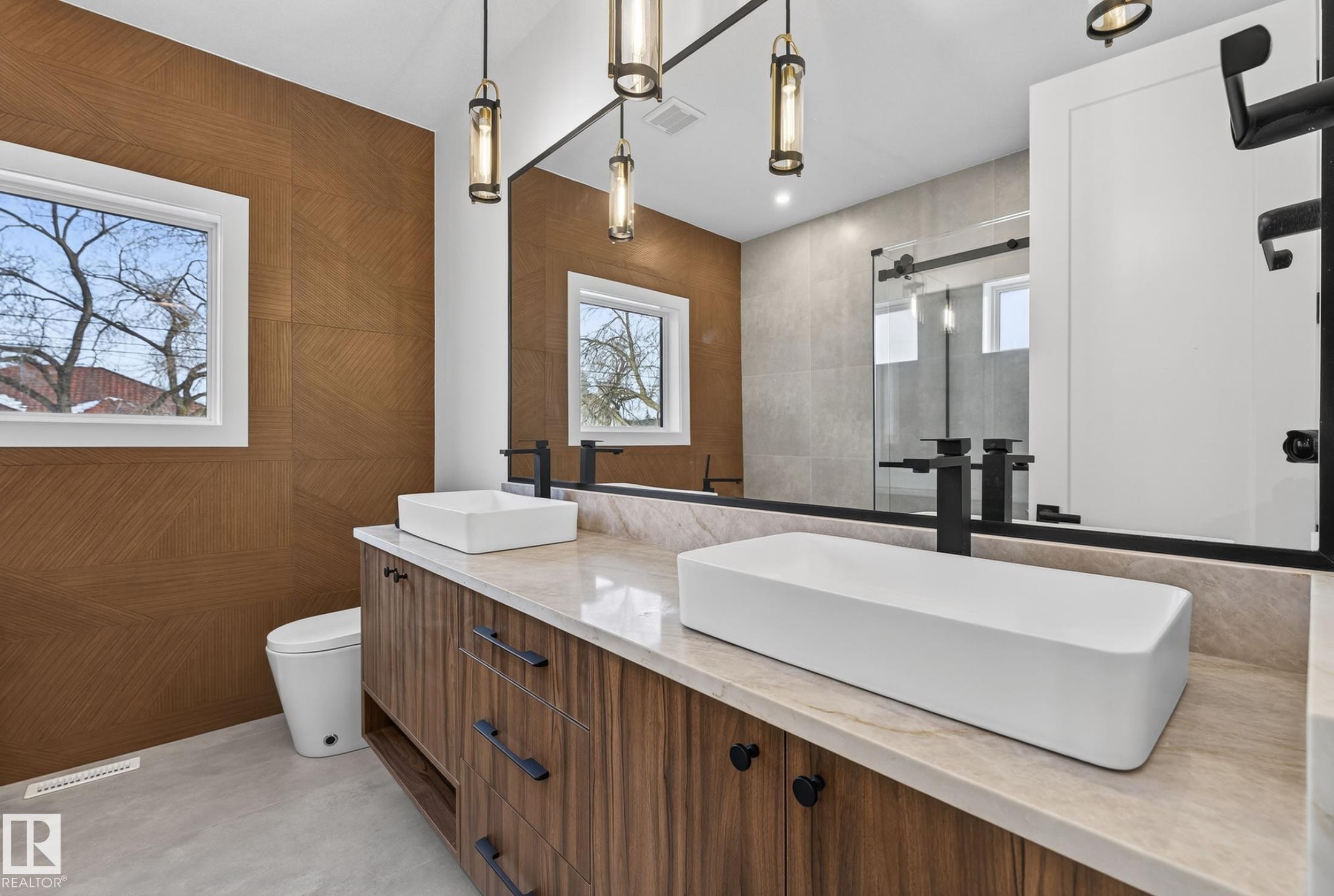 Double vanity featuring rectangular vessel sinks, wall-mounted matte black faucets, and a light-toned countertop - 5820 110 Street, Edmonton, AB - Indoor Photo Showing Bathroom
