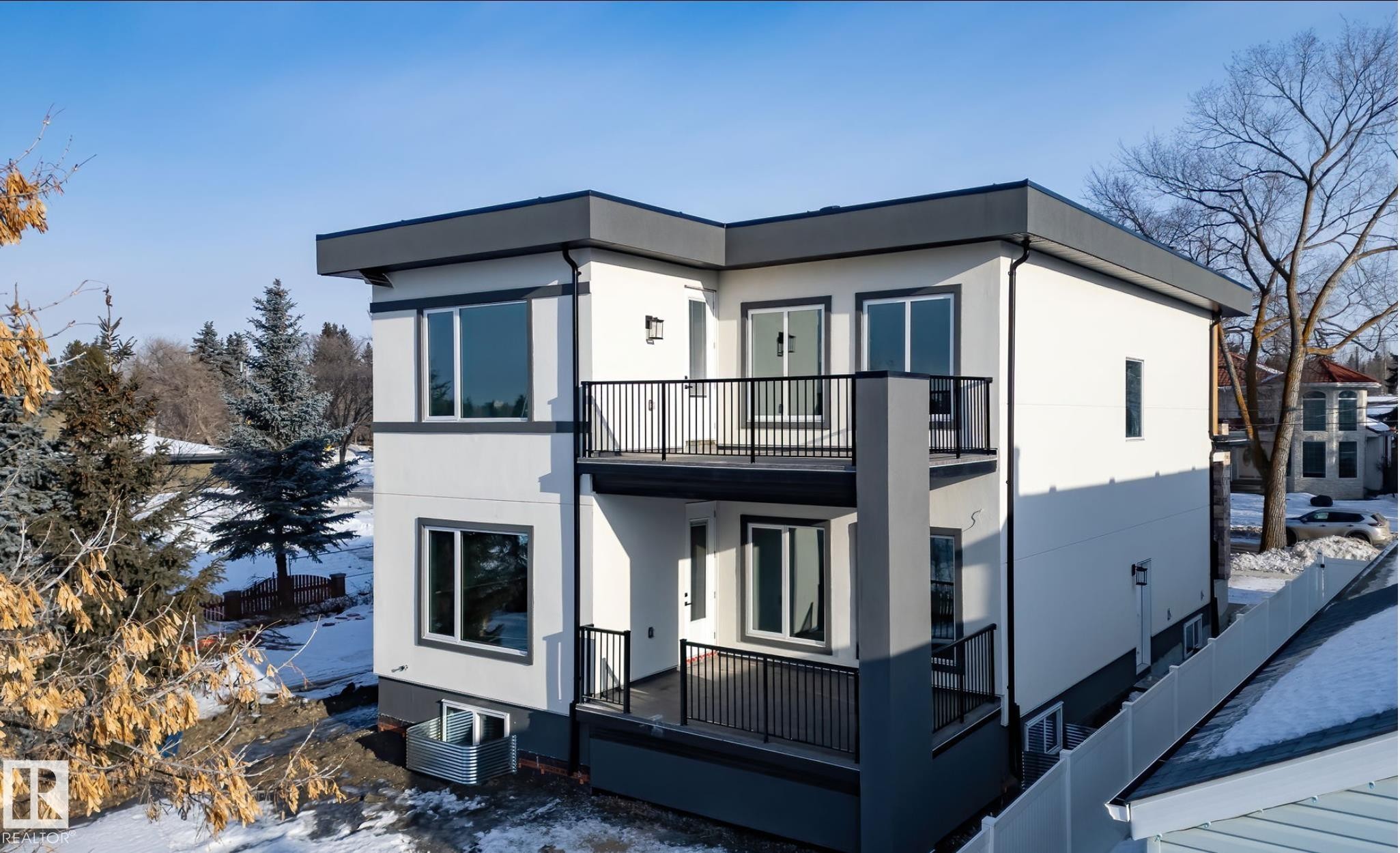Modern multi-level residence featuring a flat roofline and dark trim accents - 5820 110 Street, Edmonton, AB - Outdoor With Balcony With Exterior