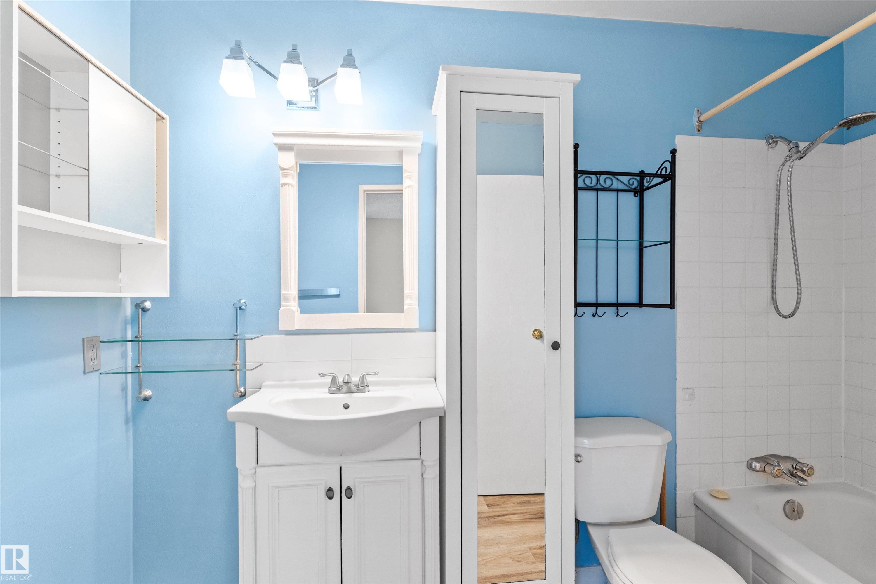 Bathroom with a white vanity sink, white toilet, and white tiled bathtub with shower - 1116 Saddleback Road, Edmonton, AB - Indoor Photo Showing Bathroom