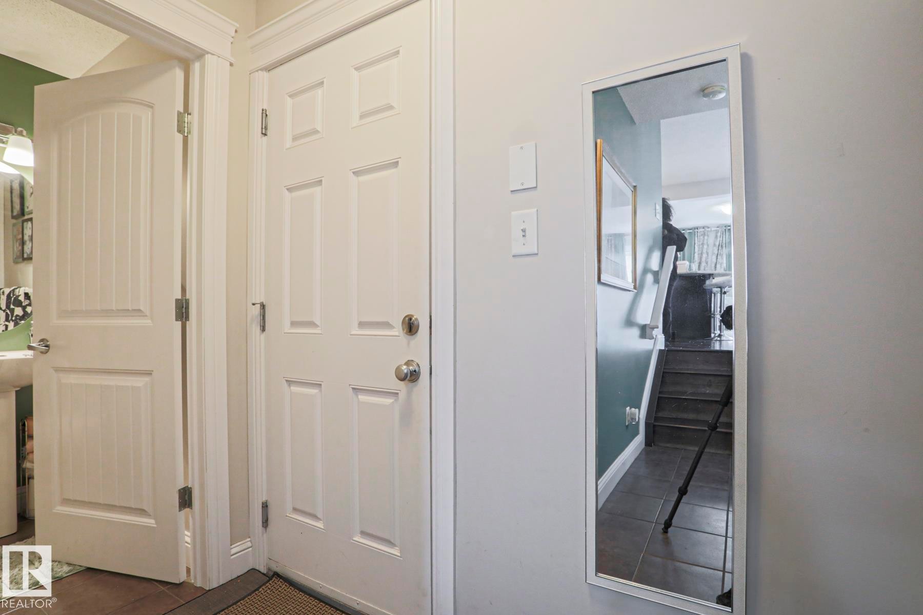 White paneled doors with chrome hardware and a full-length mirror - 1621 64 Street, Edmonton, AB - Indoor Photo Showing Other Room