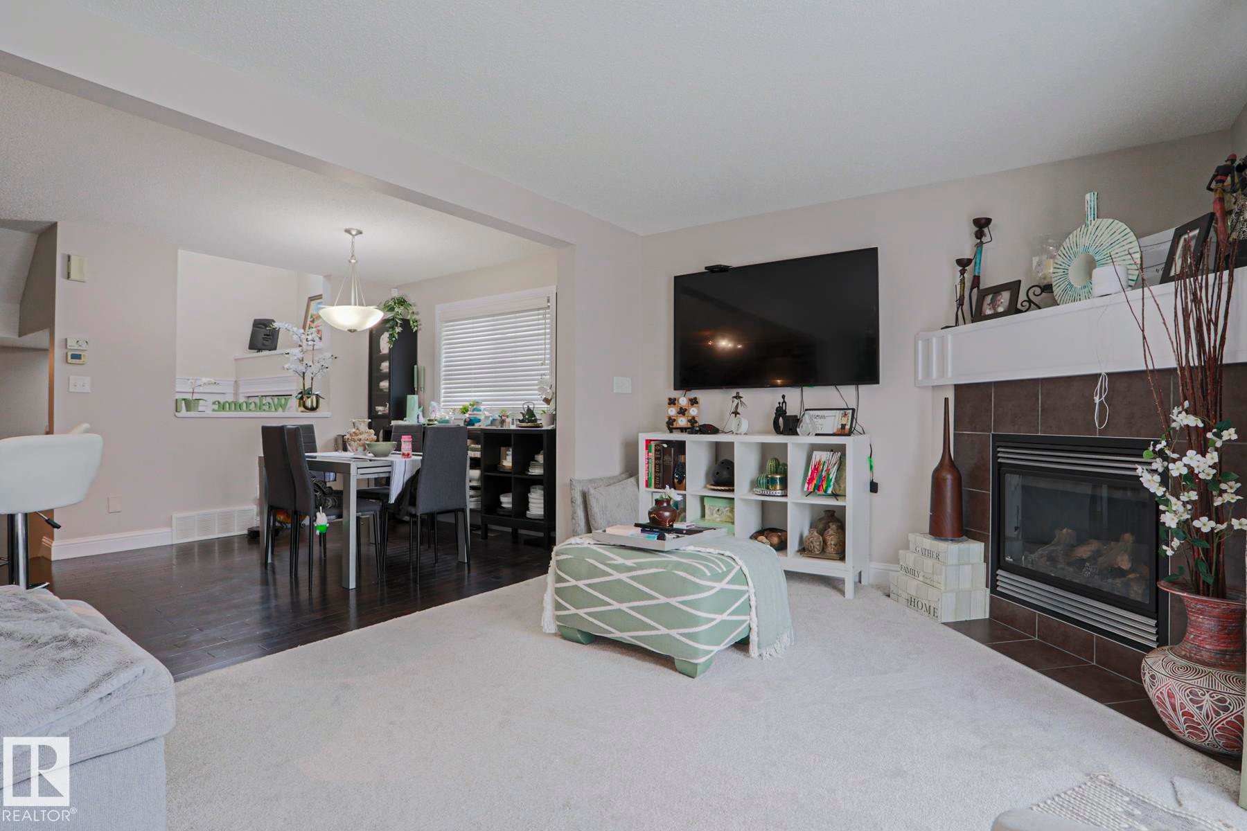 Living area featuring a fireplace with a tiled surround and white mantel - 1621 64 Street, Edmonton, AB - Indoor Photo Showing Living Room With Fireplace