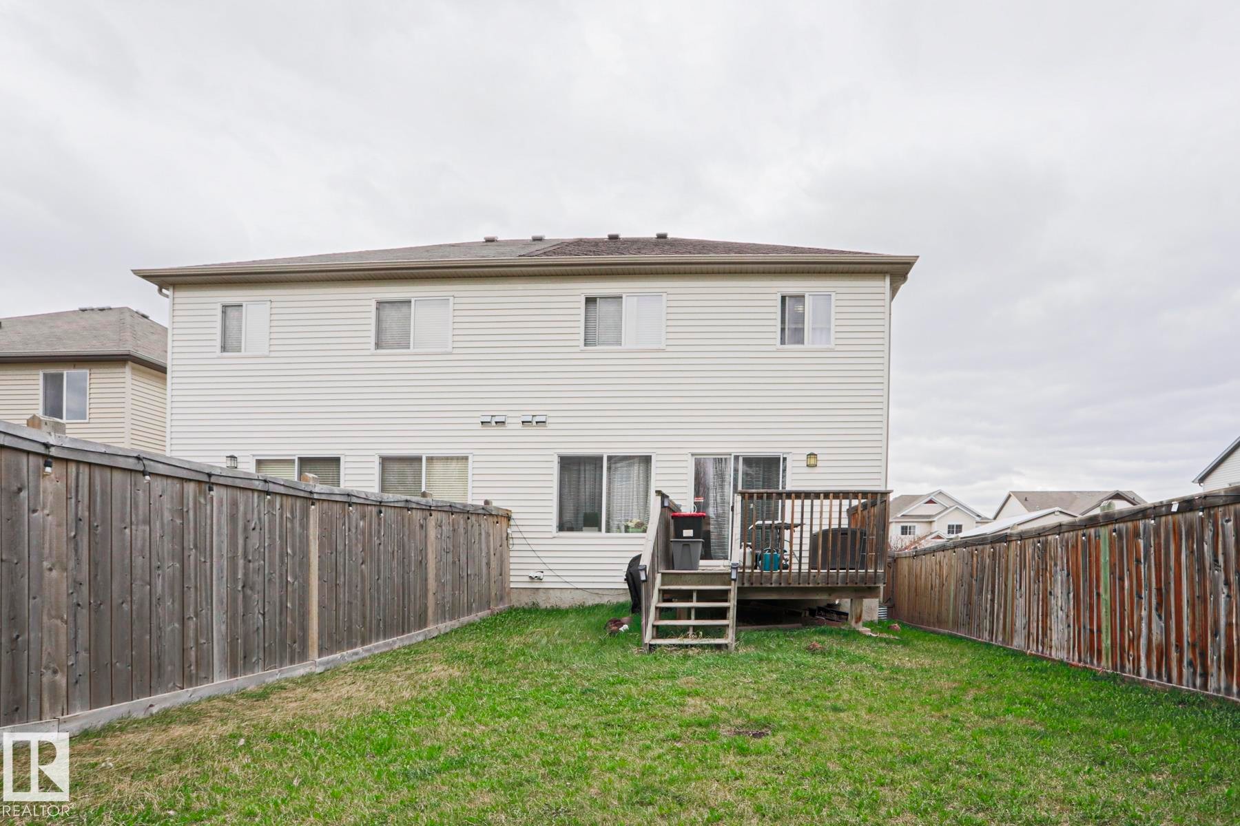 Expansive backyard featuring a wood deck with stairs, a manicured lawn, and perimeter wood fencing - 1621 64 Street, Edmonton, AB - Outdoor With Deck Patio Veranda With Exterior
