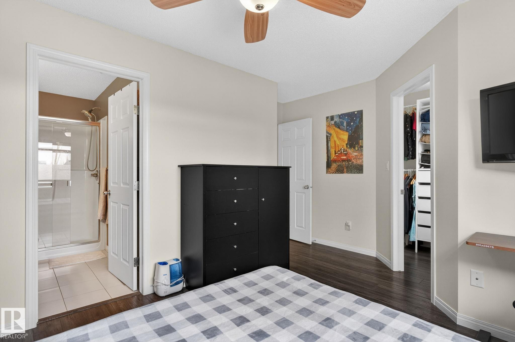 Bedroom featuring wood-finish flooring, a ceiling fan with integrated lighting, and a neutral wall color - 16 7503 Getty Gate, Edmonton, AB - Indoor Photo Showing Bedroom