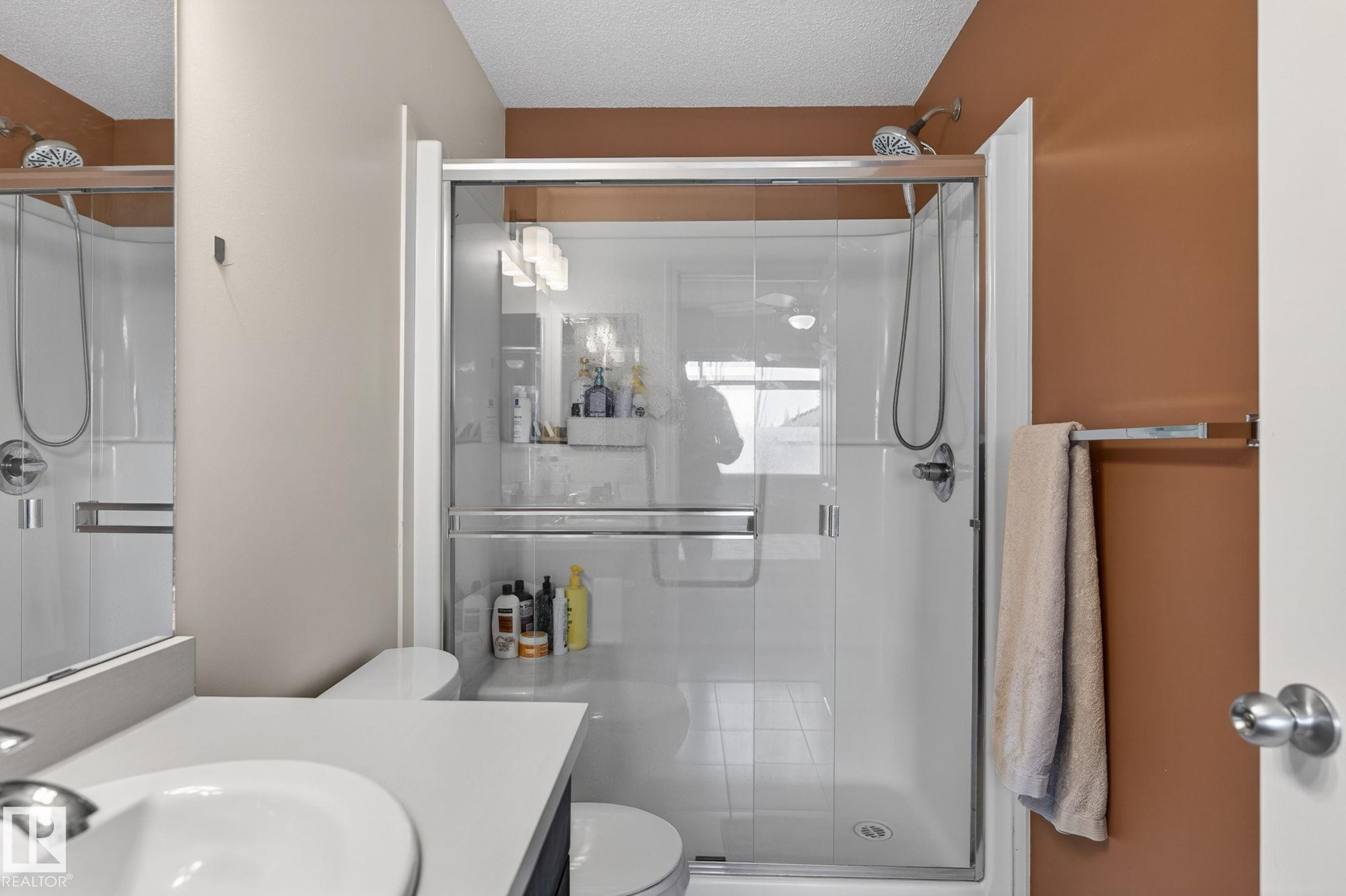 Shower enclosure featuring clear glass panels and a white shower base - 16 7503 Getty Gate, Edmonton, AB - Indoor Photo Showing Bathroom