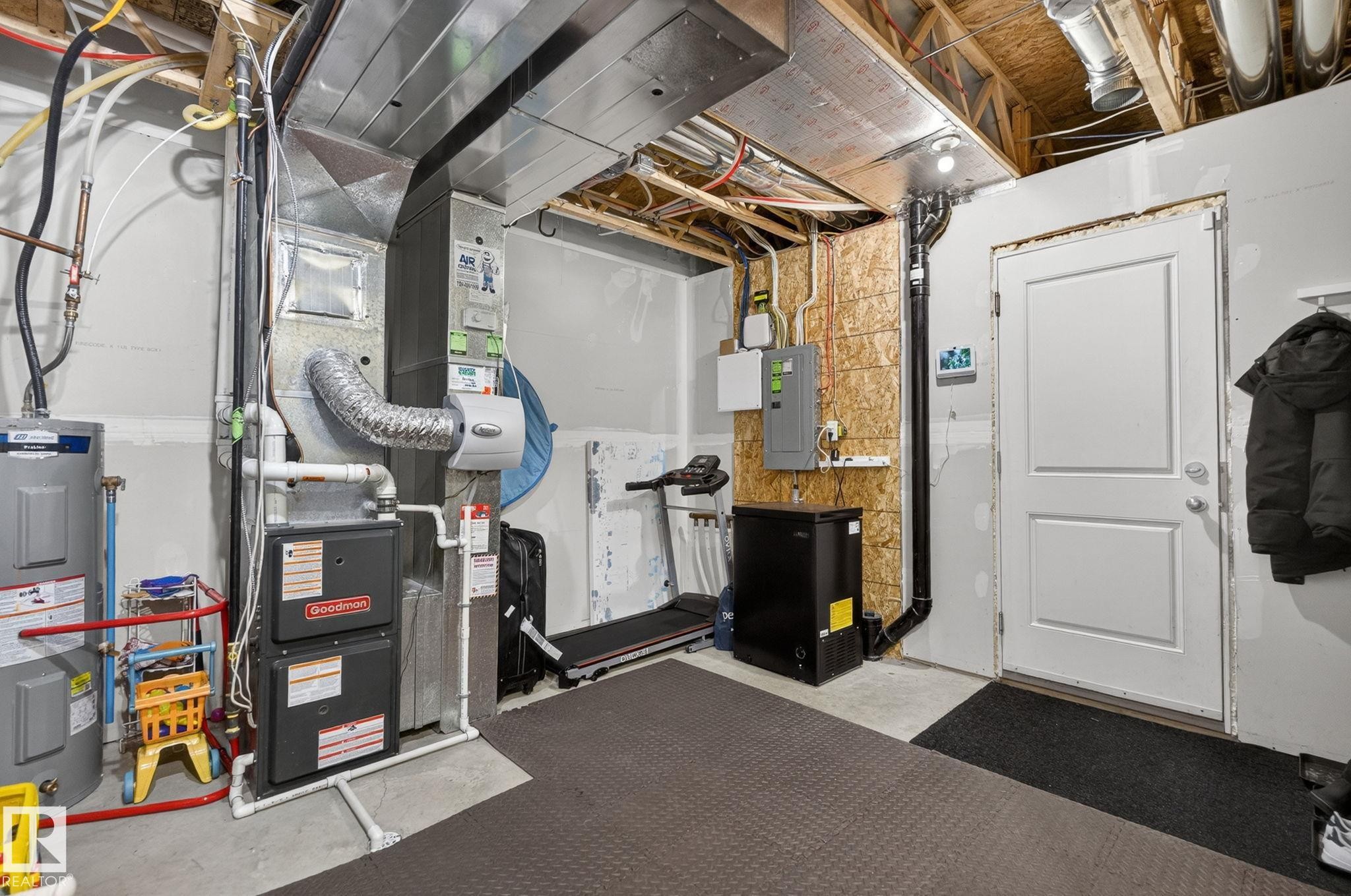 Utility room featuring a water heater, furnace, and exposed ceiling joists - 16 7503 Getty Gate, Edmonton, AB - Indoor Photo Showing Basement