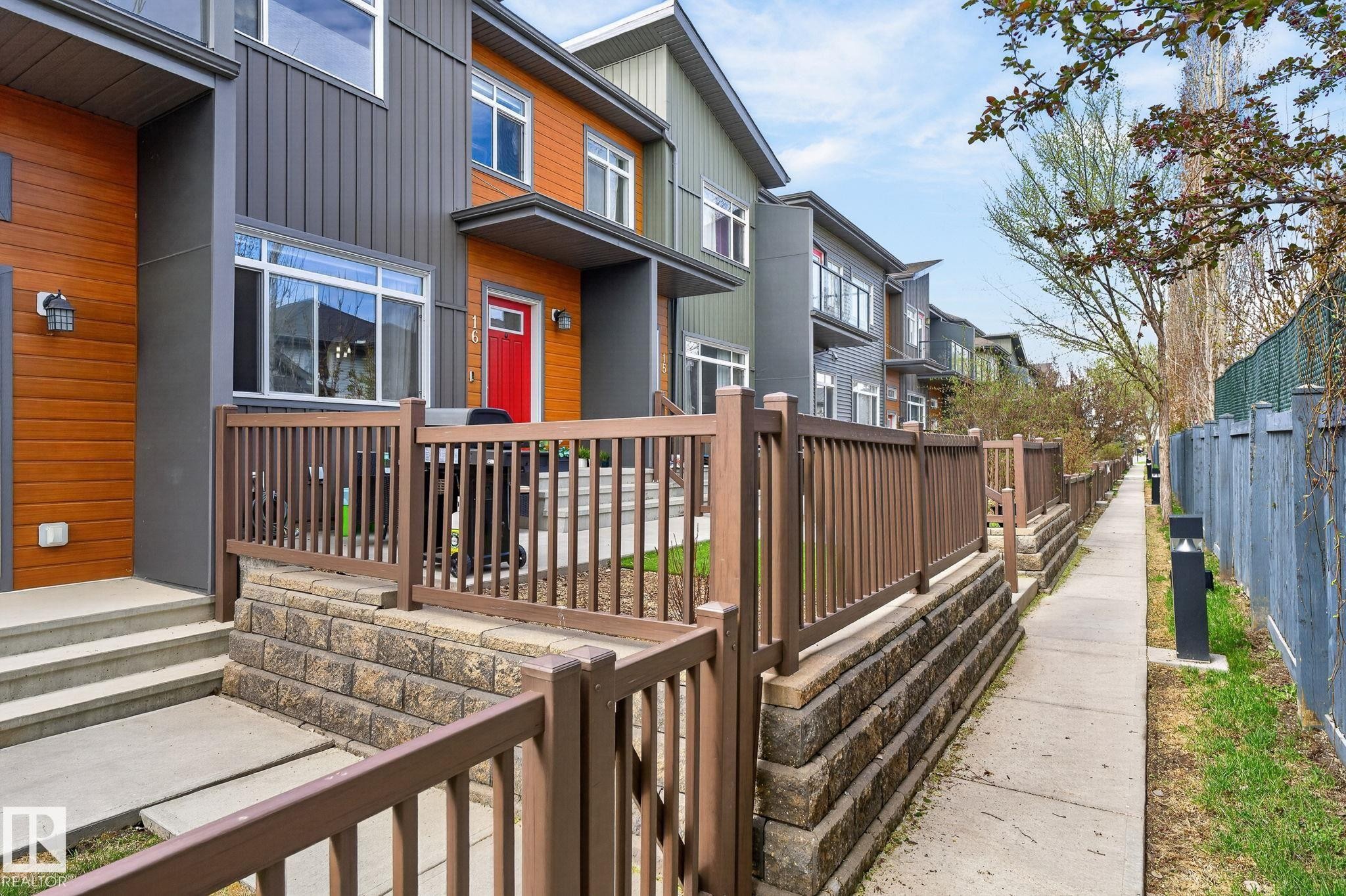 Modern multi-level townhome featuring a mixed-material facade with wood-finish siding and dark gray panels - 16 7503 Getty Gate, Edmonton, AB - Outdoor