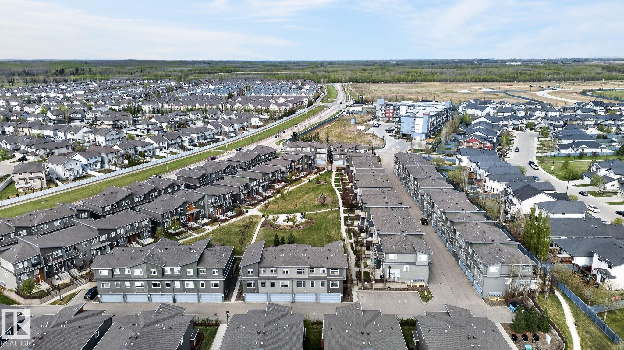 Contemporary residential development featuring rows of townhomes with attached garages - 16 7503 Getty Gate, Edmonton, AB - Outdoor With View