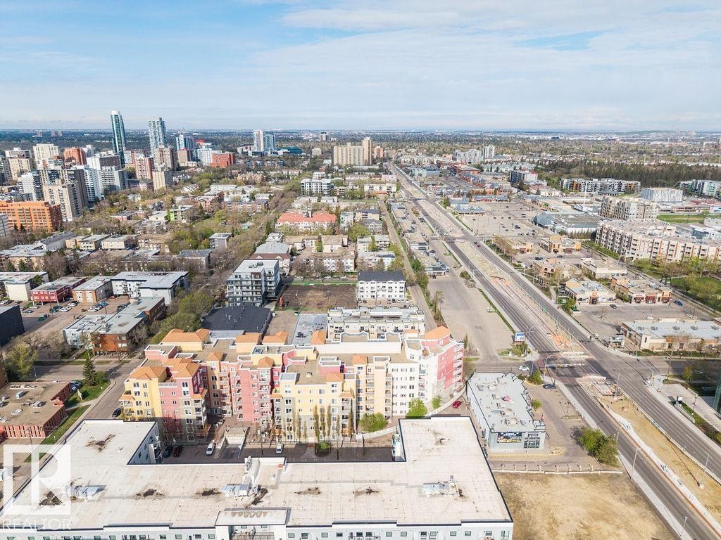 Expansive urban landscape featuring diverse architectural styles, a prominent multi-lane thoroughfare, and a distant skyline - #214 10333 112 St Nw, Edmonton, AB - Outdoor With View