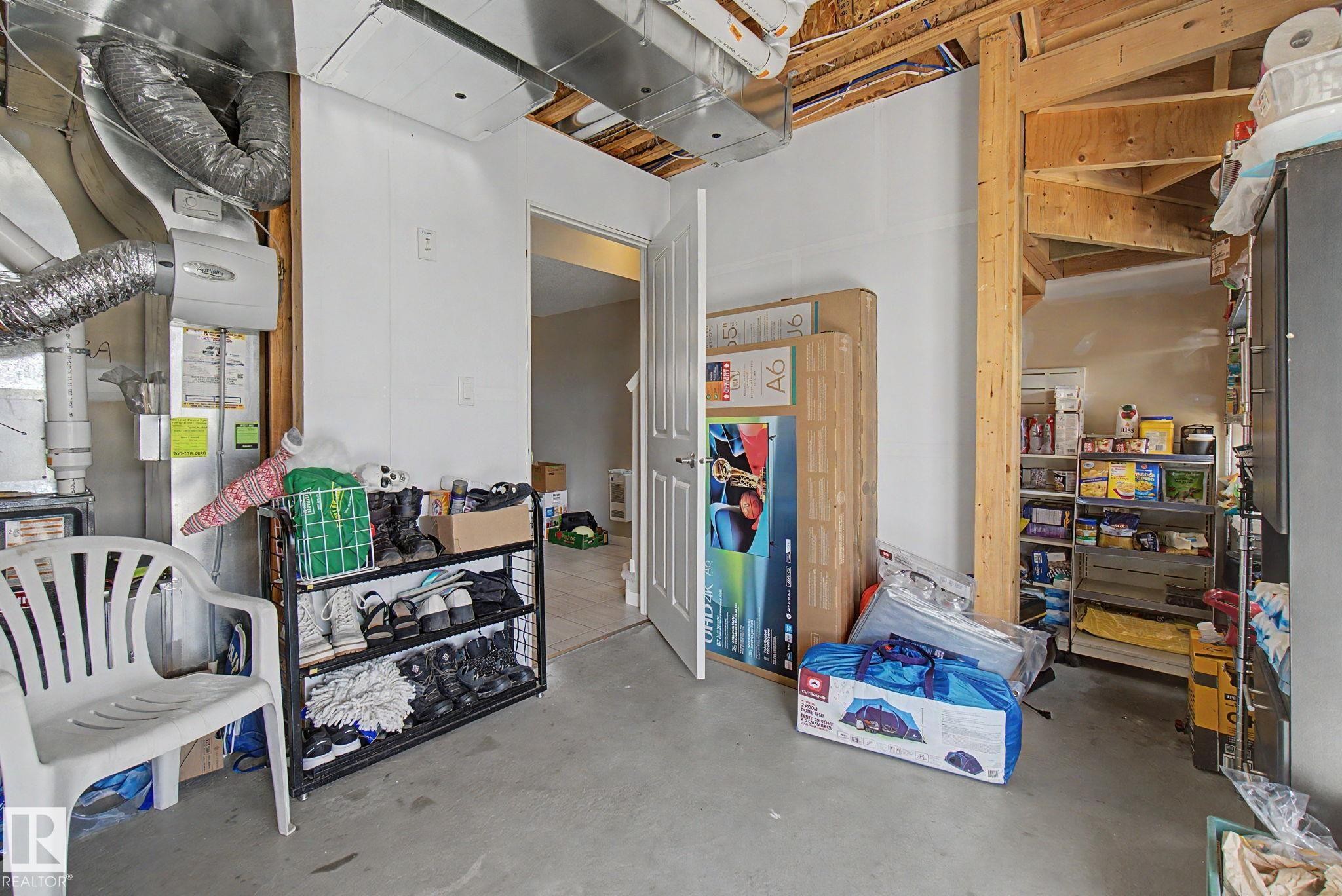 Unfinished utility space featuring exposed ductwork, exposed ceiling joists, and a concrete floor - 17 320 Secord Boulevard, Edmonton, AB - Indoor Photo Showing Other Room