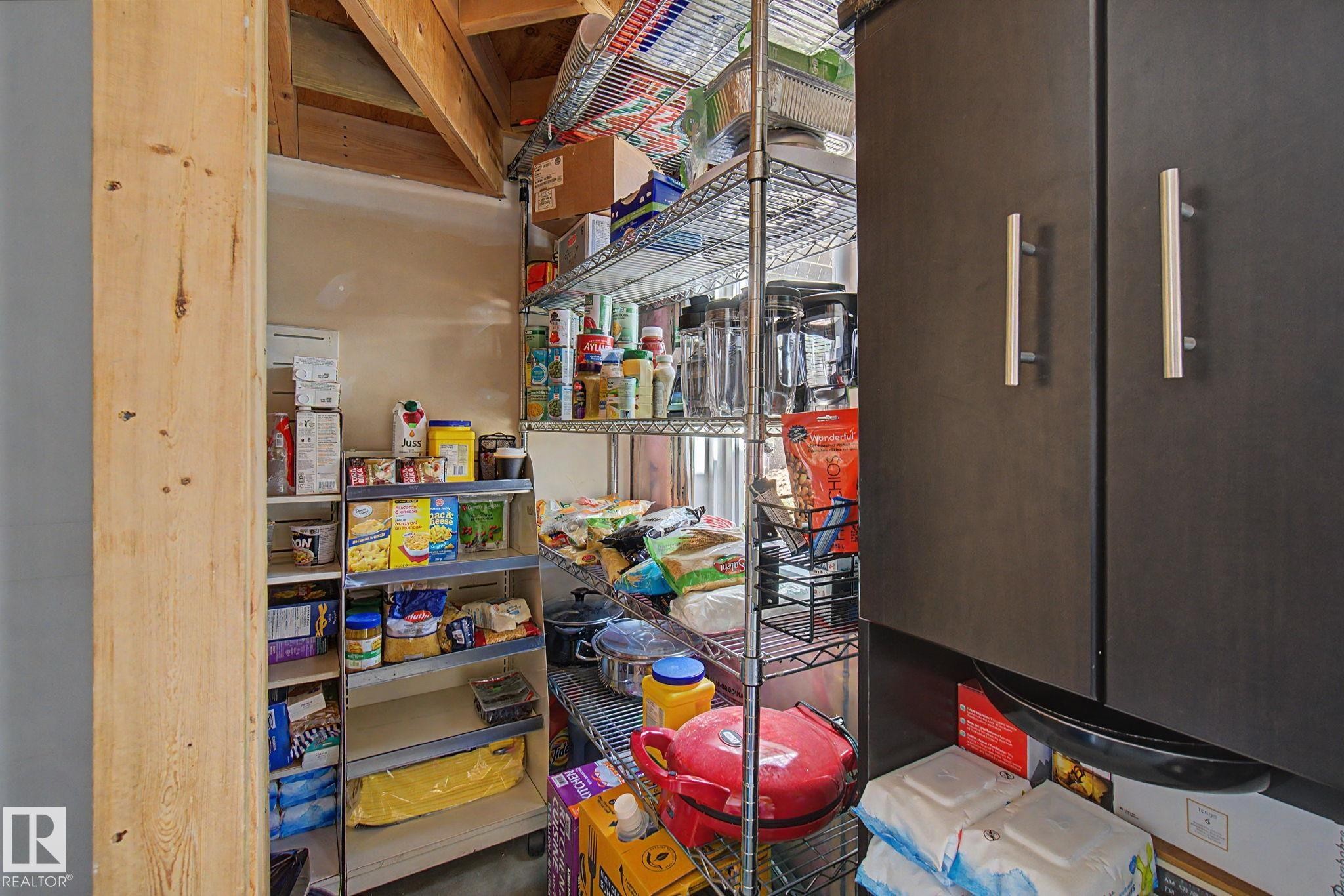 Dedicated pantry space featuring wire shelving and built-in cabinetry with brushed nickel pulls - 17 320 Secord Boulevard, Edmonton, AB - Indoor Photo Showing Other Room