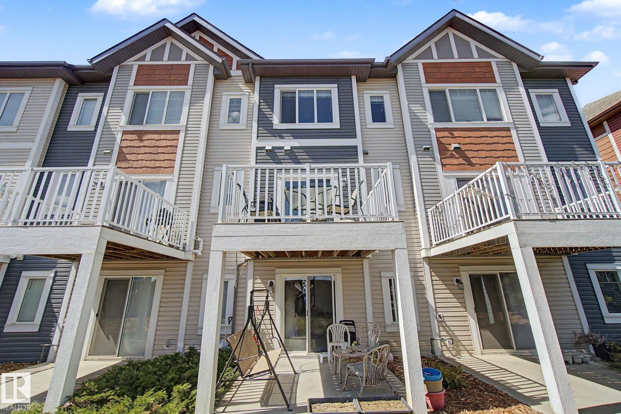 Multi-level townhome featuring a private balcony and ground-level patio - 17 320 Secord Boulevard, Edmonton, AB - Outdoor With Facade