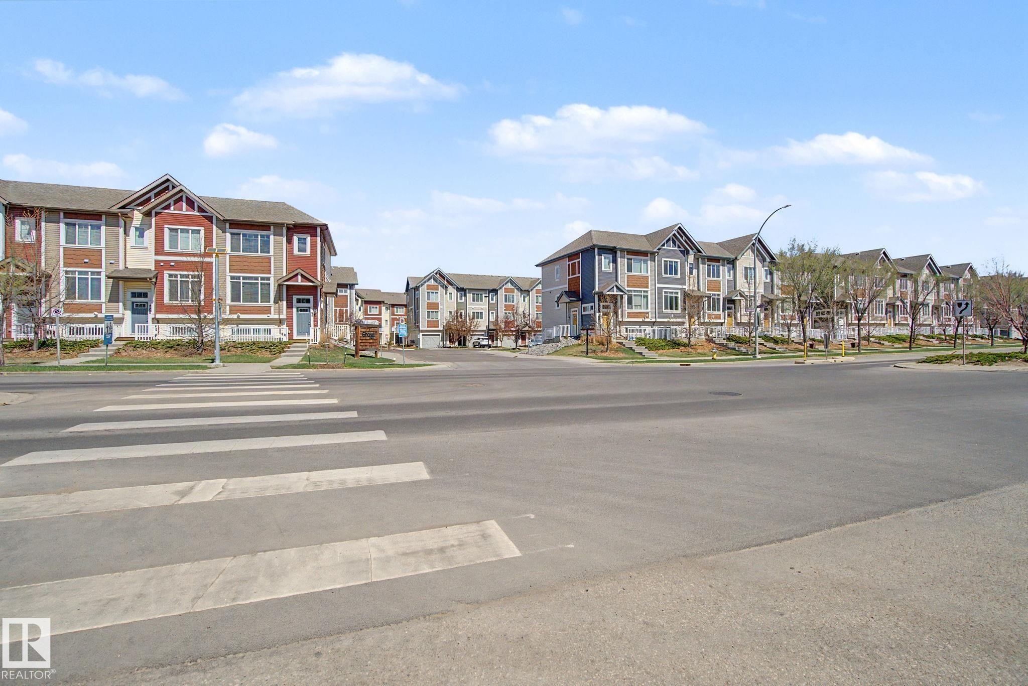 Contemporary townhome community featuring diverse exterior finishes, multiple gables, and prominent windows - 17 320 Secord Boulevard, Edmonton, AB - Outdoor With Facade