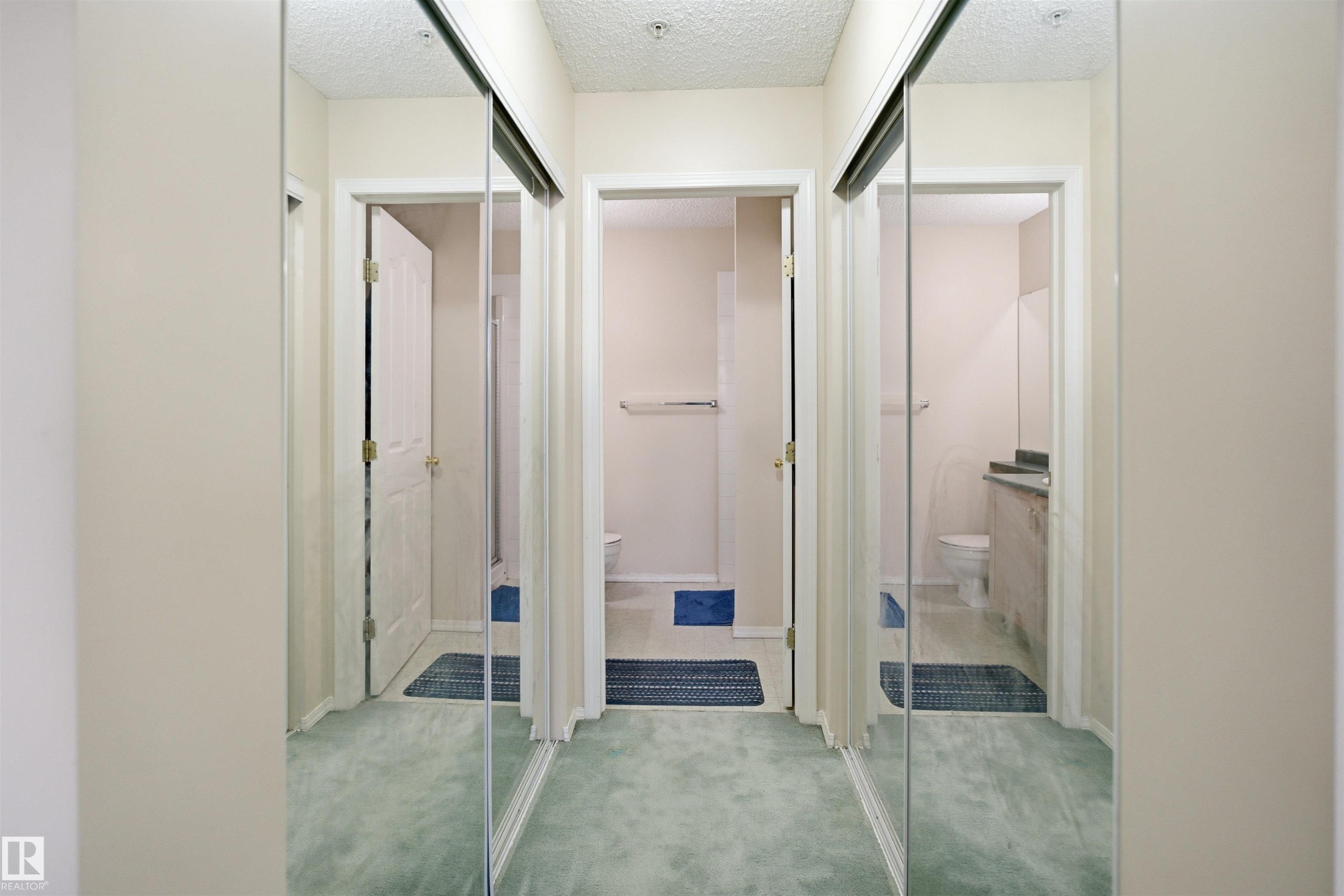 Mirrored closet doors featuring a metal track system and light-colored walls - 124 10511 42 Avenue, Edmonton, AB