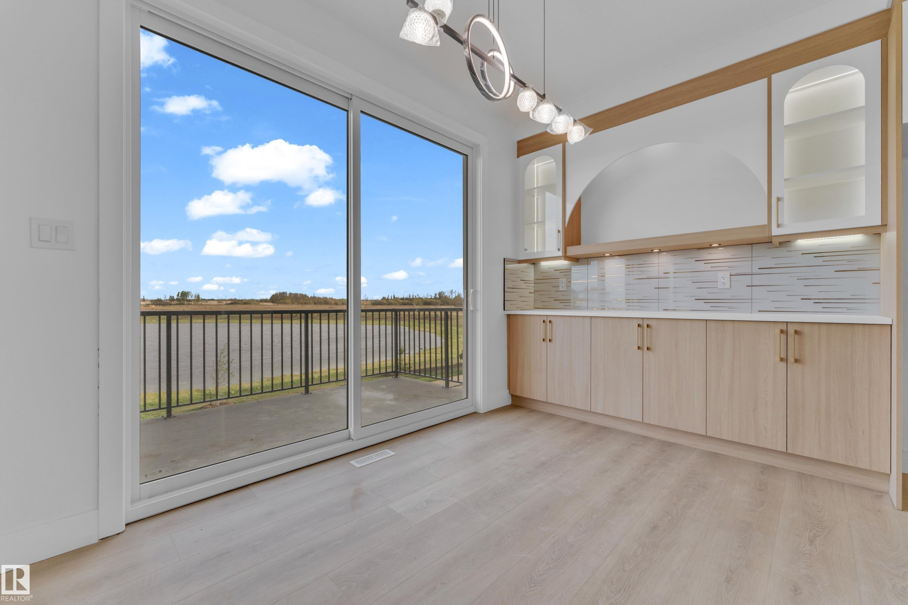 Sliding glass doors opening to a balcony with black metal railings - 449 Crystal Creek Link, Leduc, AB - Photo Showing Other Room