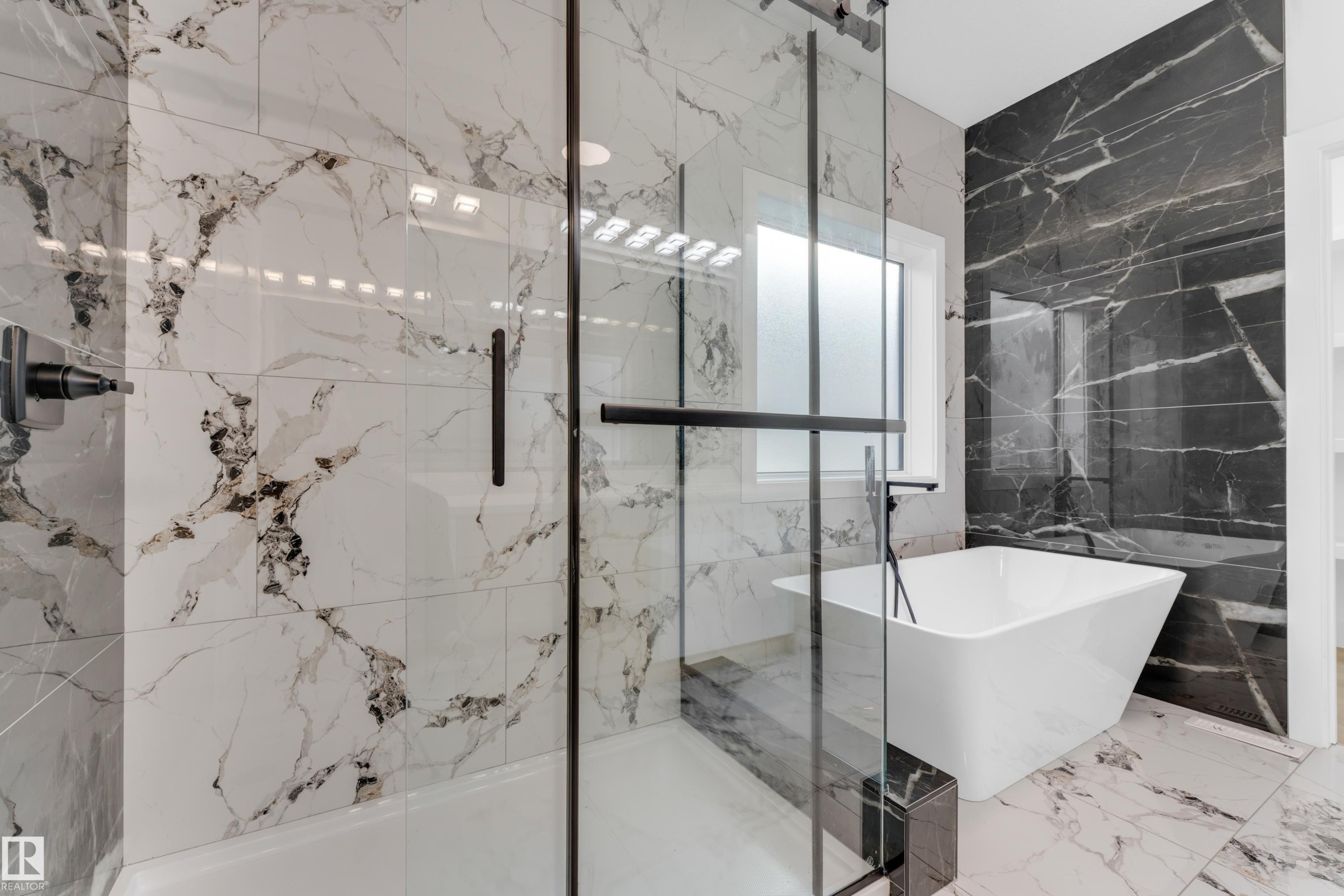 Bathroom featuring a spacious walk-in shower with clear glass enclosure and a freestanding soaking tub - 449 Crystal Creek Link, Leduc, AB - Indoor Photo Showing Bathroom