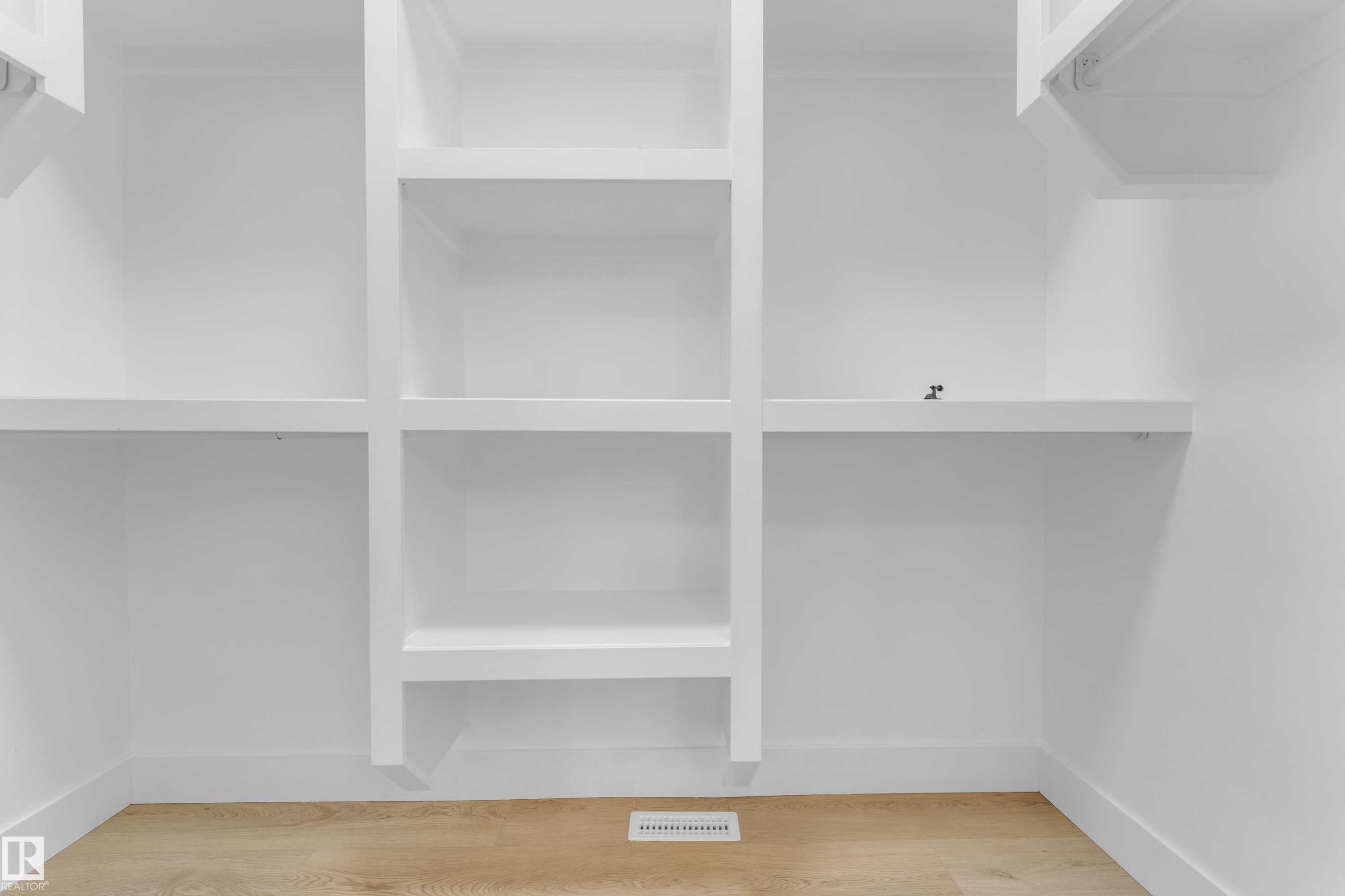 Custom built-in white shelving and hanging rods - 449 Crystal Creek Link, Leduc, AB - Indoor With Storage