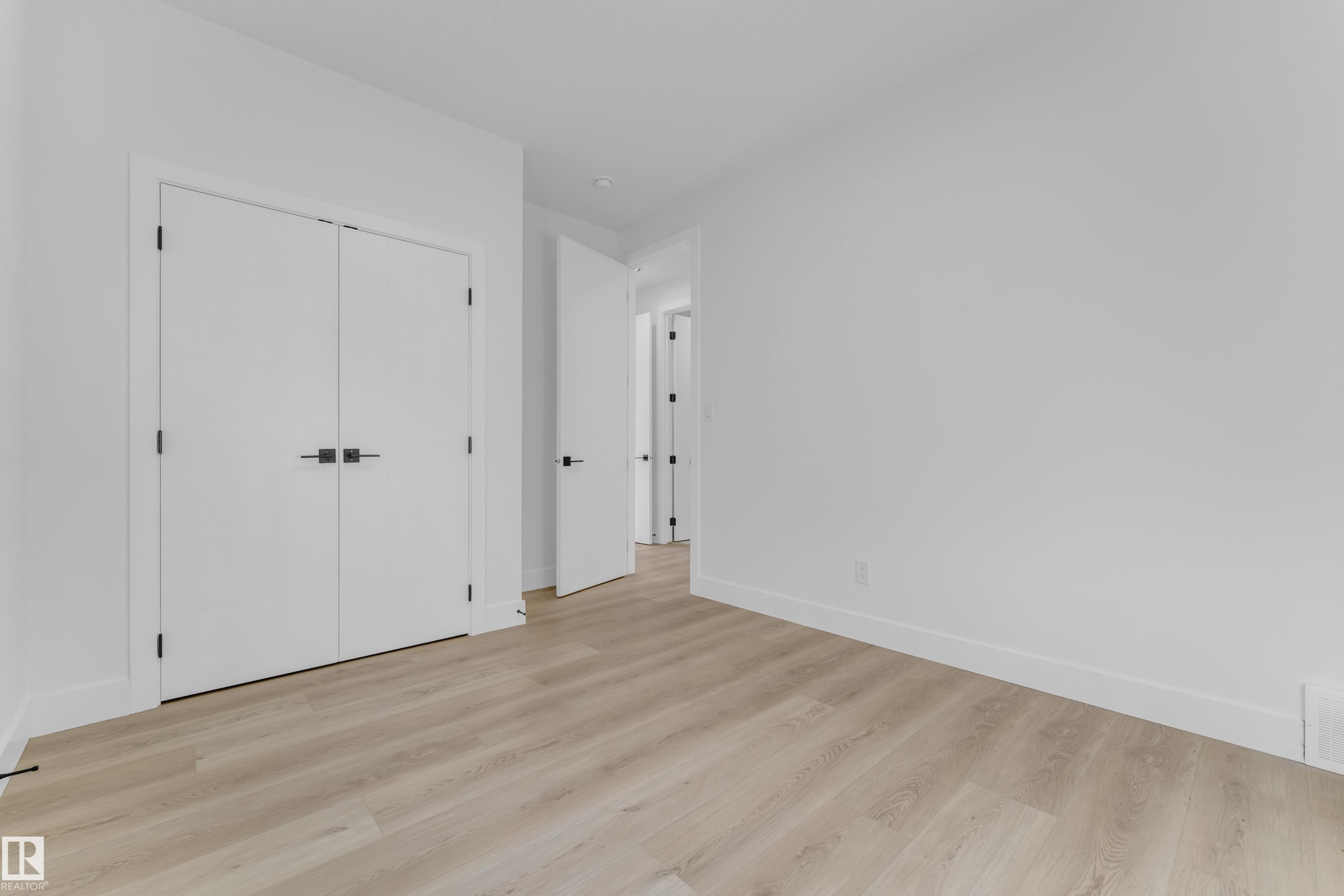 Spacious interior with light wood-finish flooring - 449 Crystal Creek Link, Leduc, AB - Indoor Photo Showing Other Room