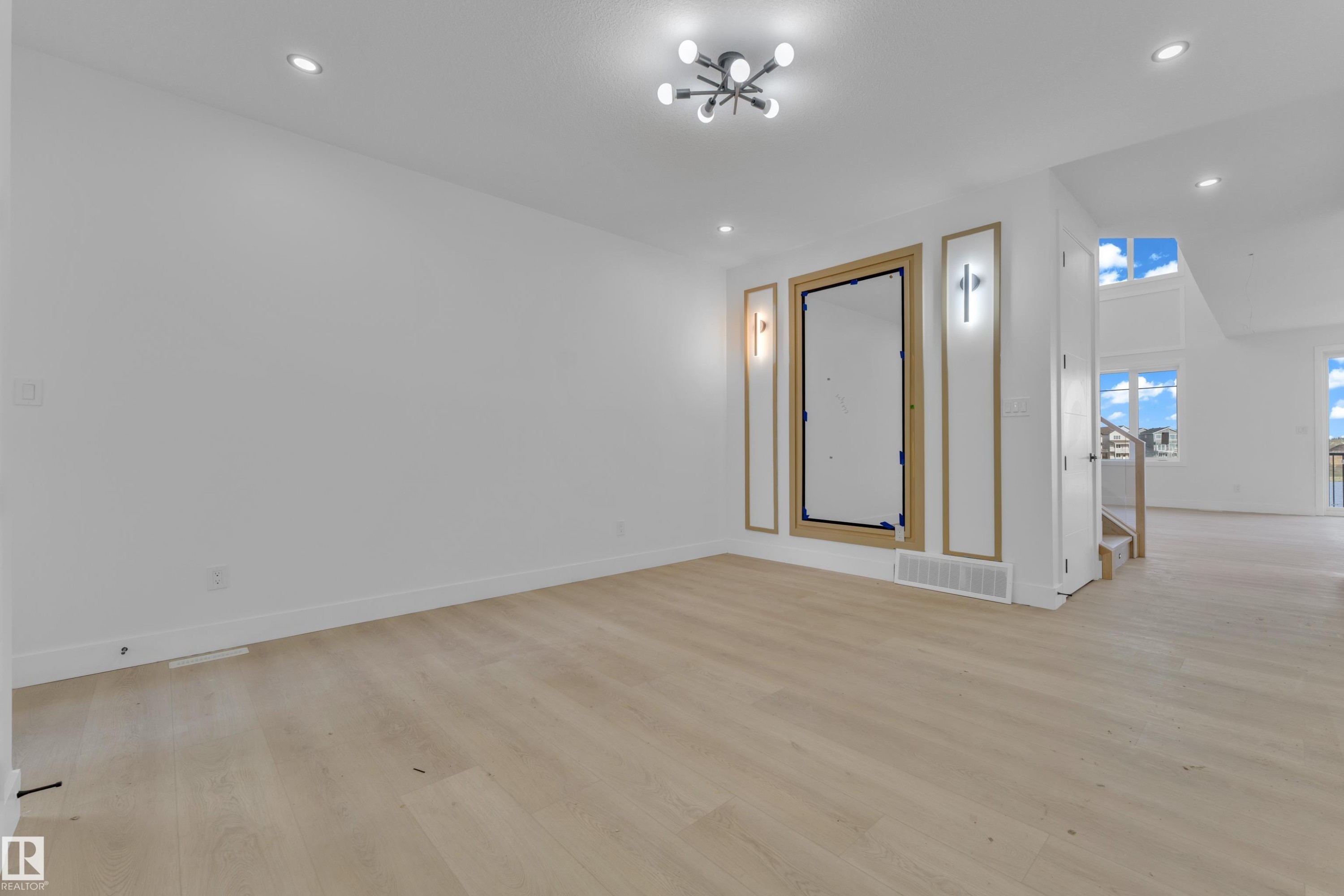 Spacious room featuring wood-finish flooring, recessed lighting, and a contemporary ceiling fixture - 449 Crystal Creek Link, Leduc, AB - Indoor Photo Showing Other Room