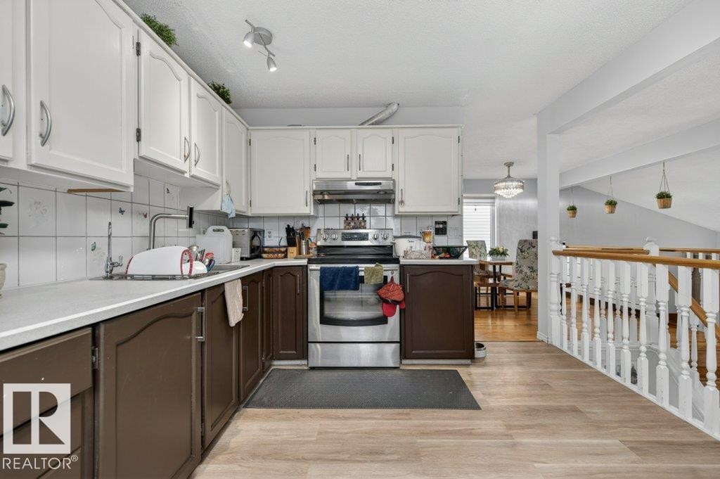 Kitchen featuring two-tone cabinetry, white countertops, and white square tile backsplash - 157 Kiniski Crescent, Edmonton, AB - Indoor Photo Showing Kitchen