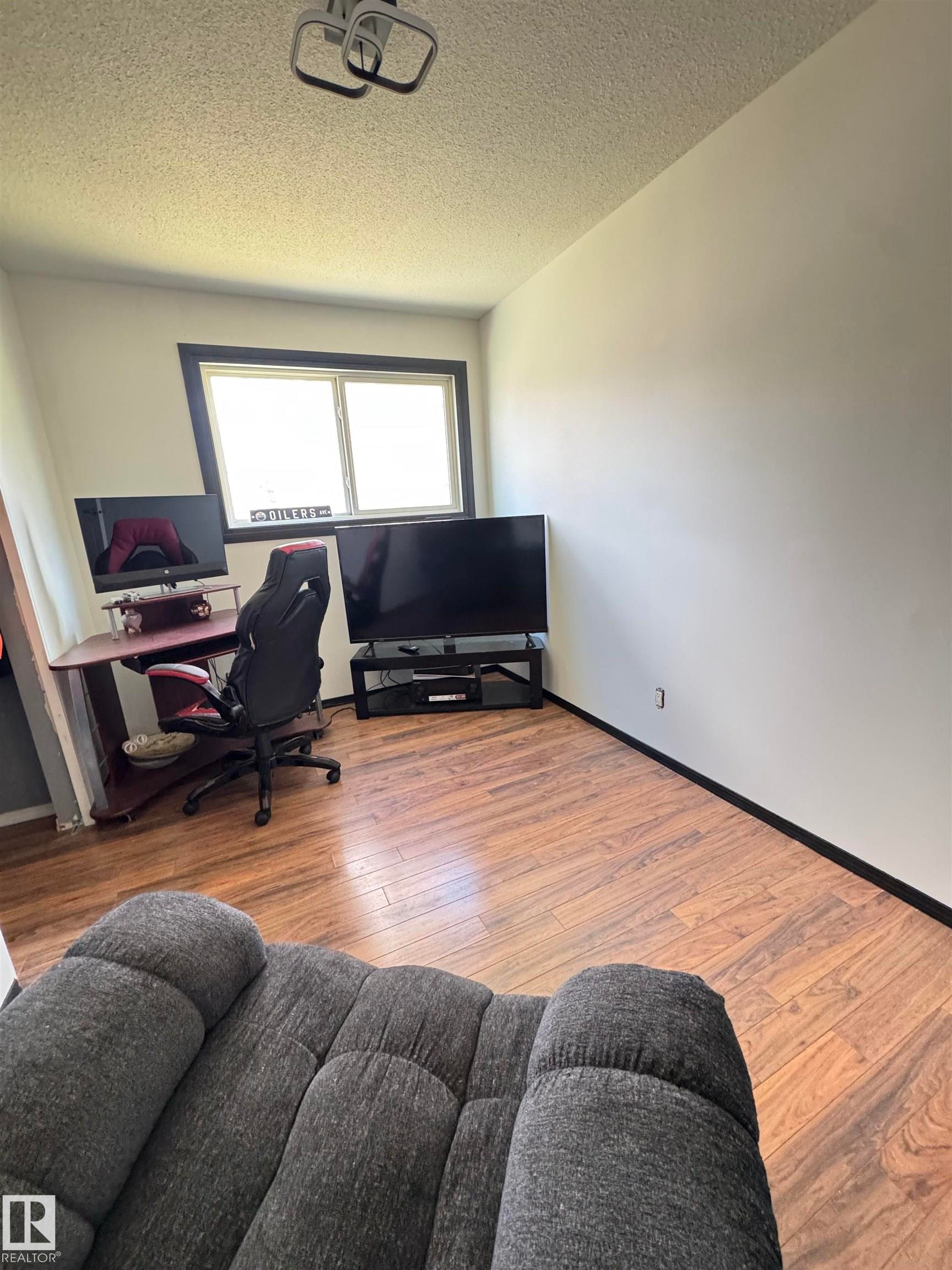 Room featuring wood-finish flooring, a window with dark trim, and light-colored walls - 45 Lambert Crescent, St. Albert, AB - Indoor Photo Showing Office