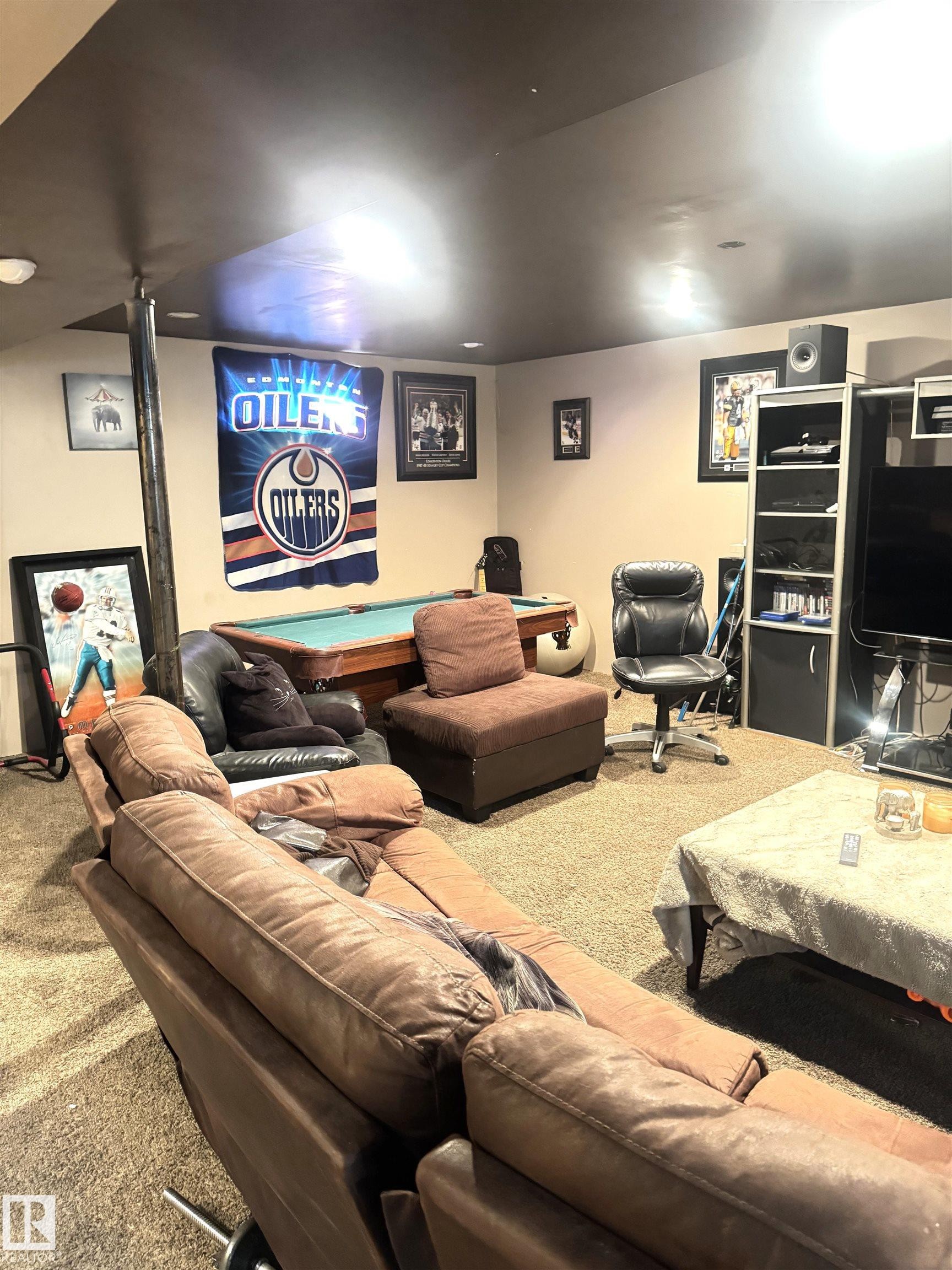 Recessed lighting illuminates a spacious room featuring a pool table, wall-mounted display, and carpeted flooring - 45 Lambert Crescent, St. Albert, AB - Indoor