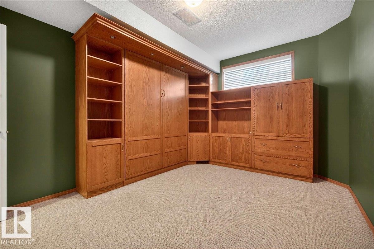 Built-in oak cabinetry with integrated shelving and a folding bed system - 11824 13 Avenue, Edmonton, AB - Indoor Photo Showing Other Room