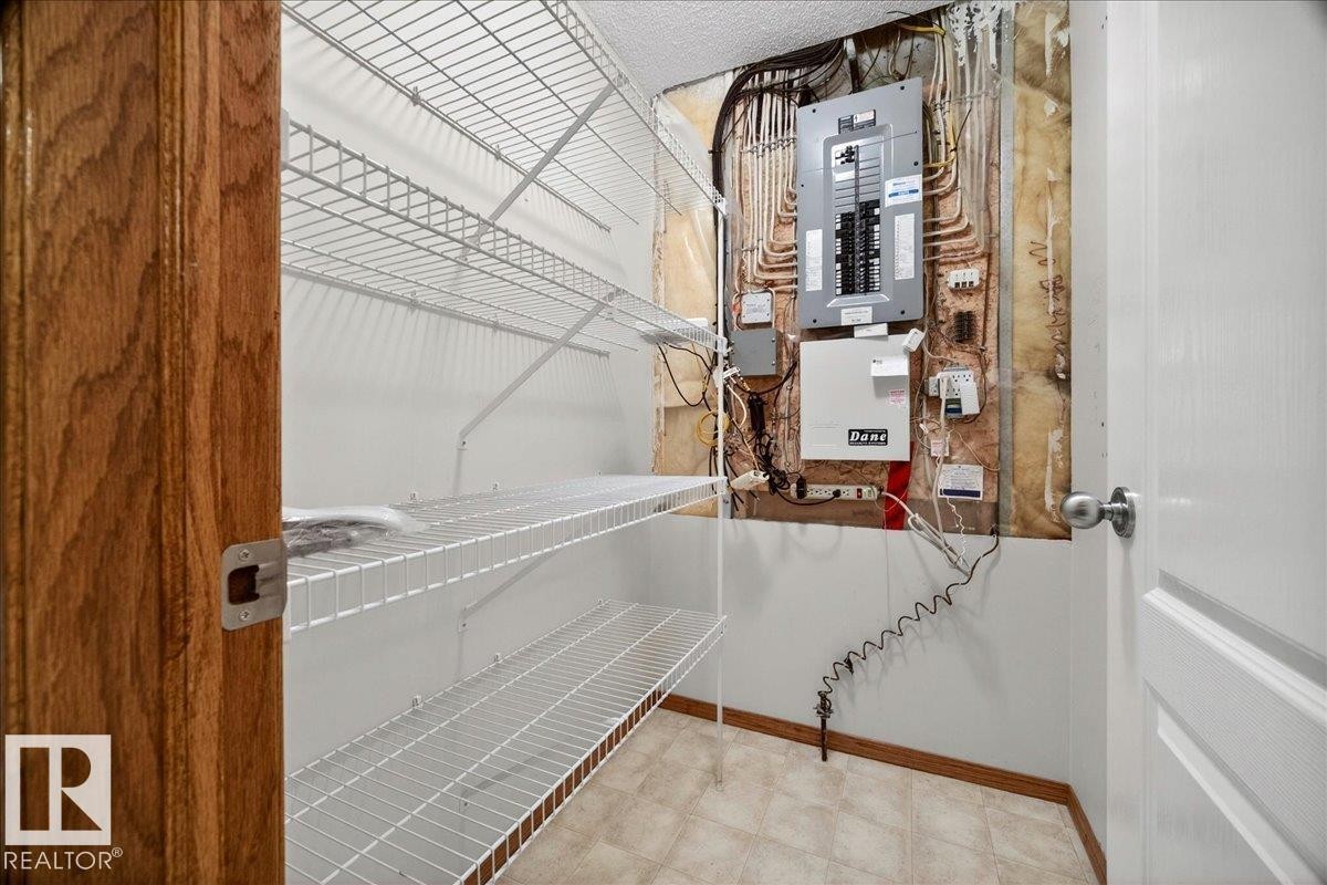 Utility closet with white wire shelving, a wood-finish door frame, and a white interior door - 11824 13 Avenue, Edmonton, AB - Indoor