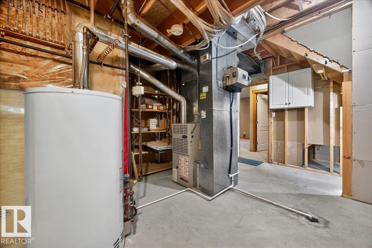 Utility area featuring a water heater, furnace, exposed ductwork, and unfinished wall construction - 11824 13 Avenue, Edmonton, AB - Indoor Photo Showing Basement