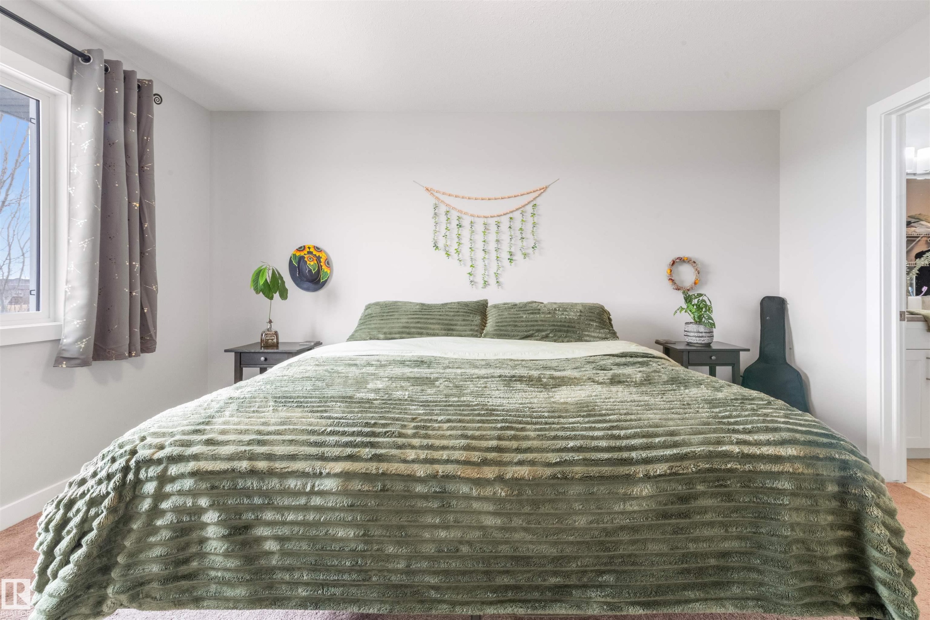 This sleeping space features light-colored walls and a window with a dark curtain - 607 40 Street Sw, Edmonton, AB - Indoor Photo Showing Bedroom